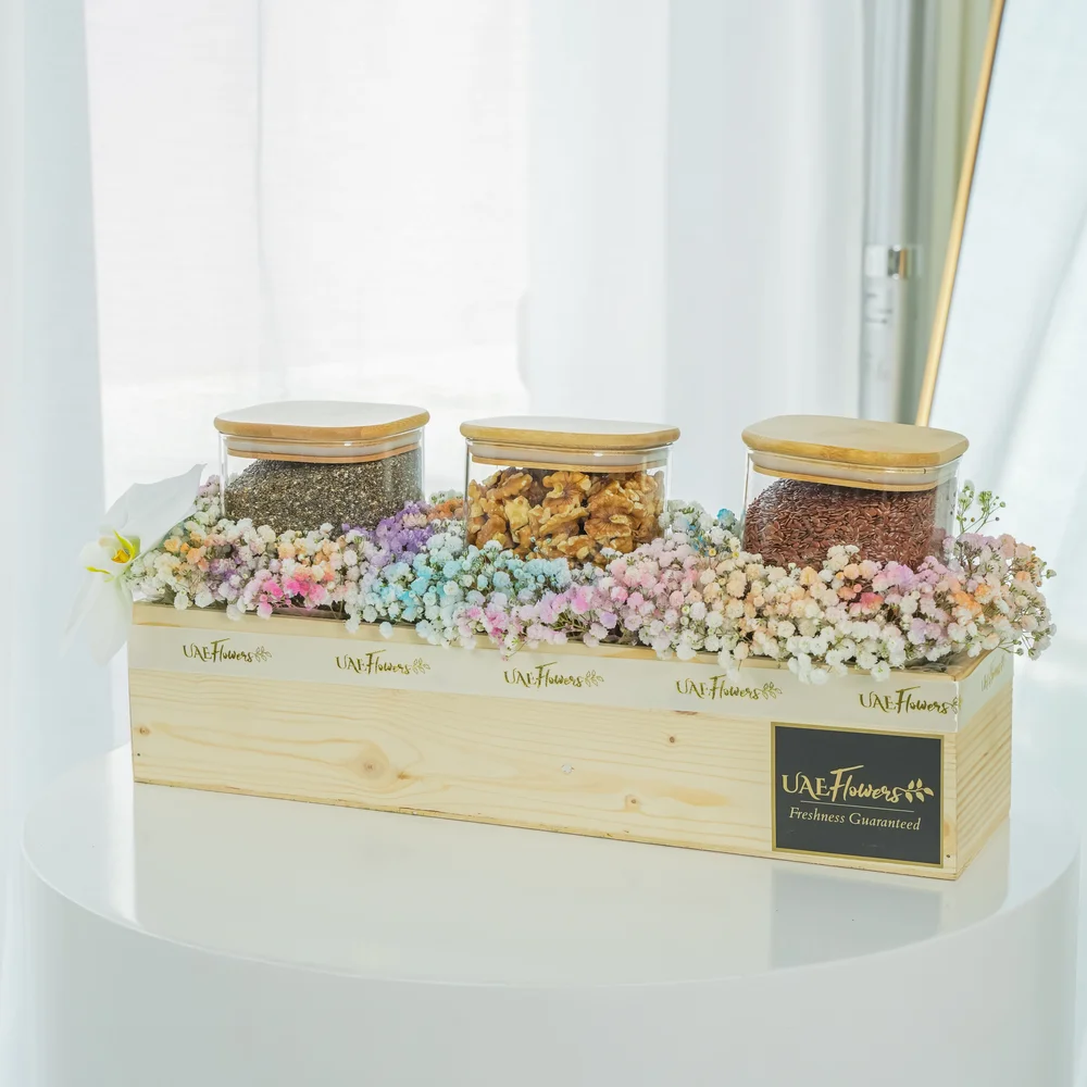 Collection of white cymbidium orchid, Chia seeds, Walnuts, Flax seeds and pastel colored baby's breath around the wooden box.