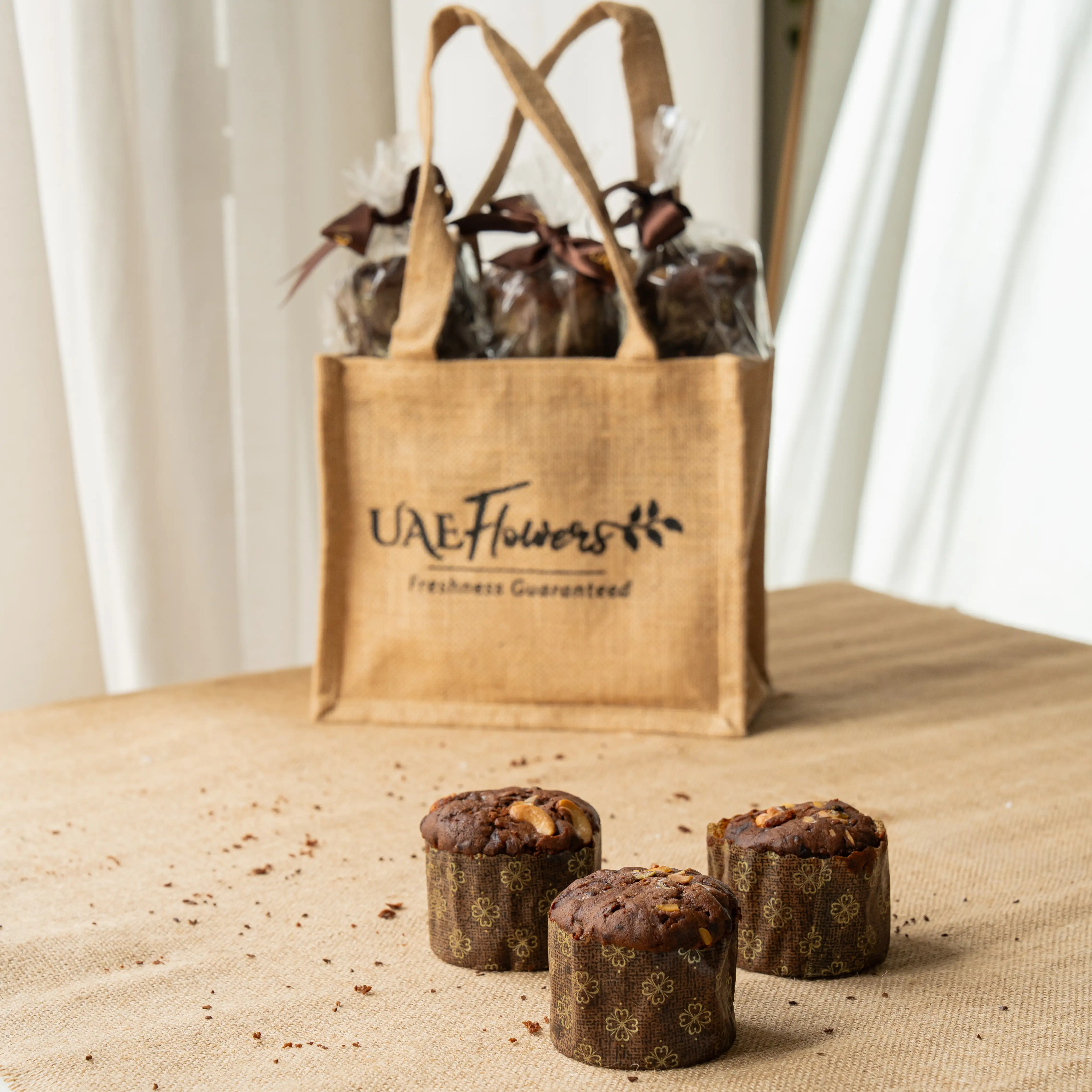 Mini plum cupcakes topped with nuts on festive packaging