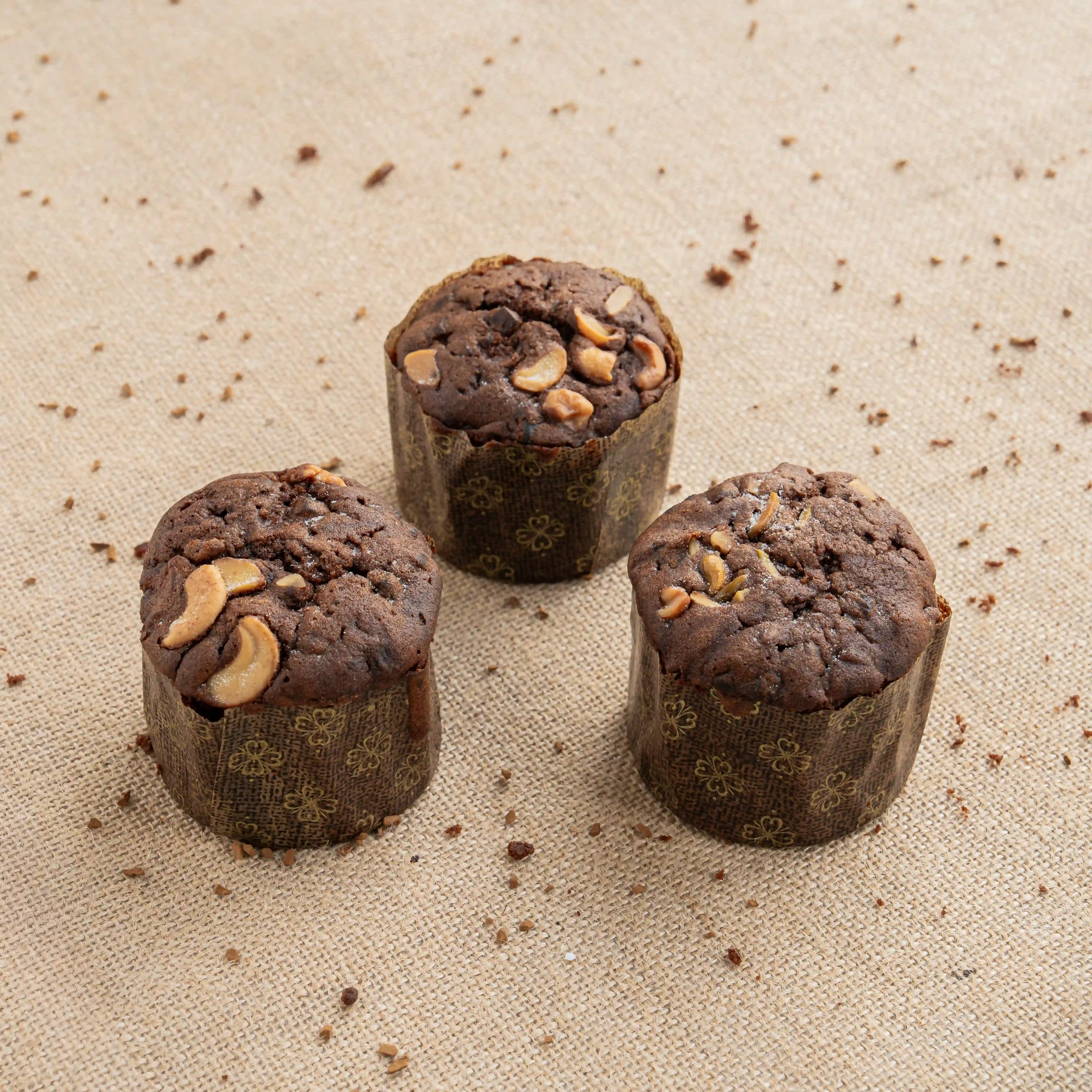 Mini plum cupcakes topped with nuts on festive packaging