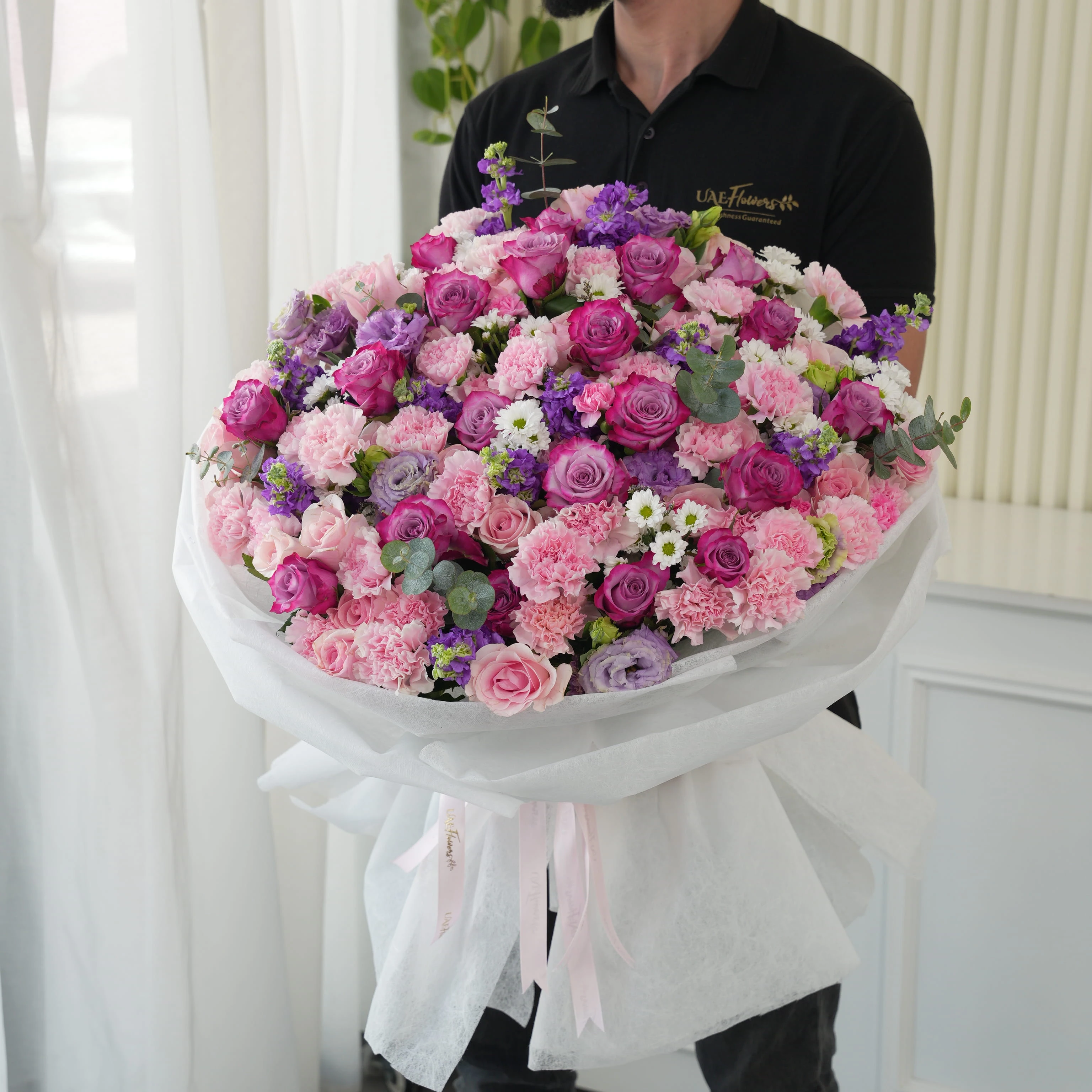 Bouquet of 10 purple matthiola, 10 white chrysanthemums, 10 purple lisianthus, 30 pink carnations, 20 purple roses and 40 pink roses with green fillers in nice wrapping.