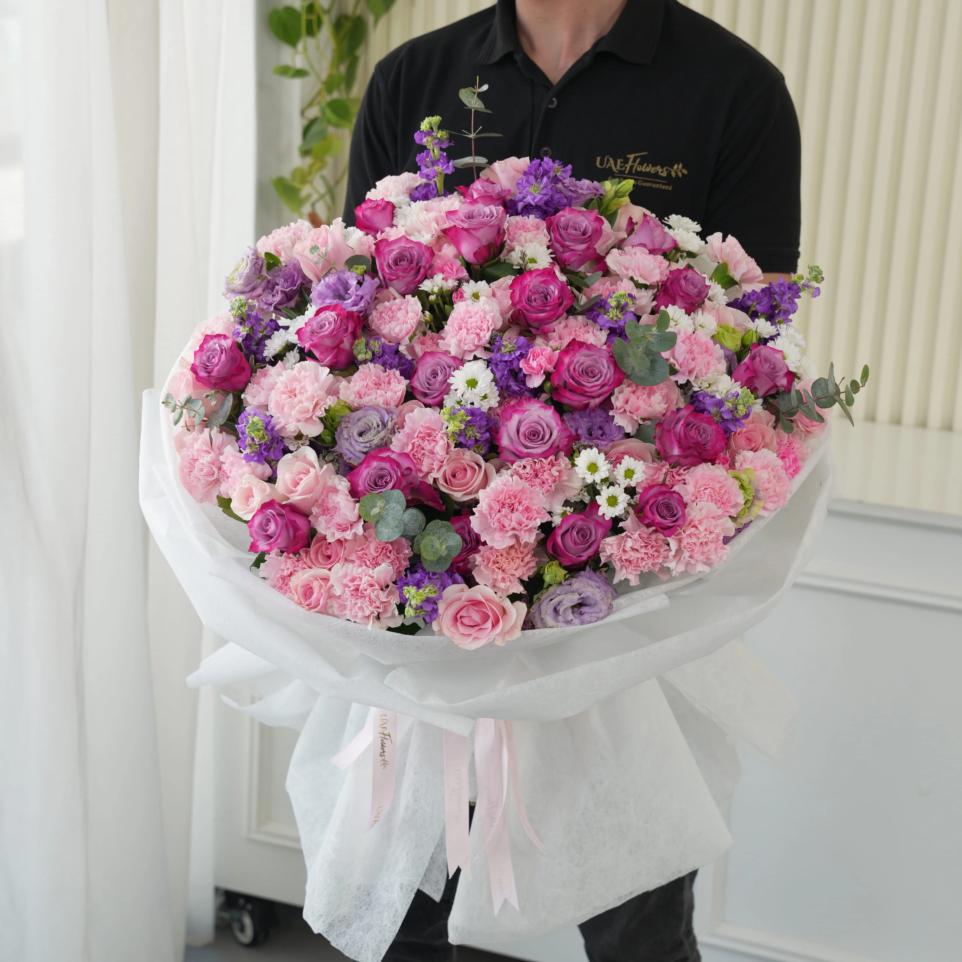 Bouquet of 10 purple matthiola, 10 white chrysanthemums, 10 purple lisianthus, 30 pink carnations, 20 purple roses and 40 pink roses with green fillers in nice wrapping.