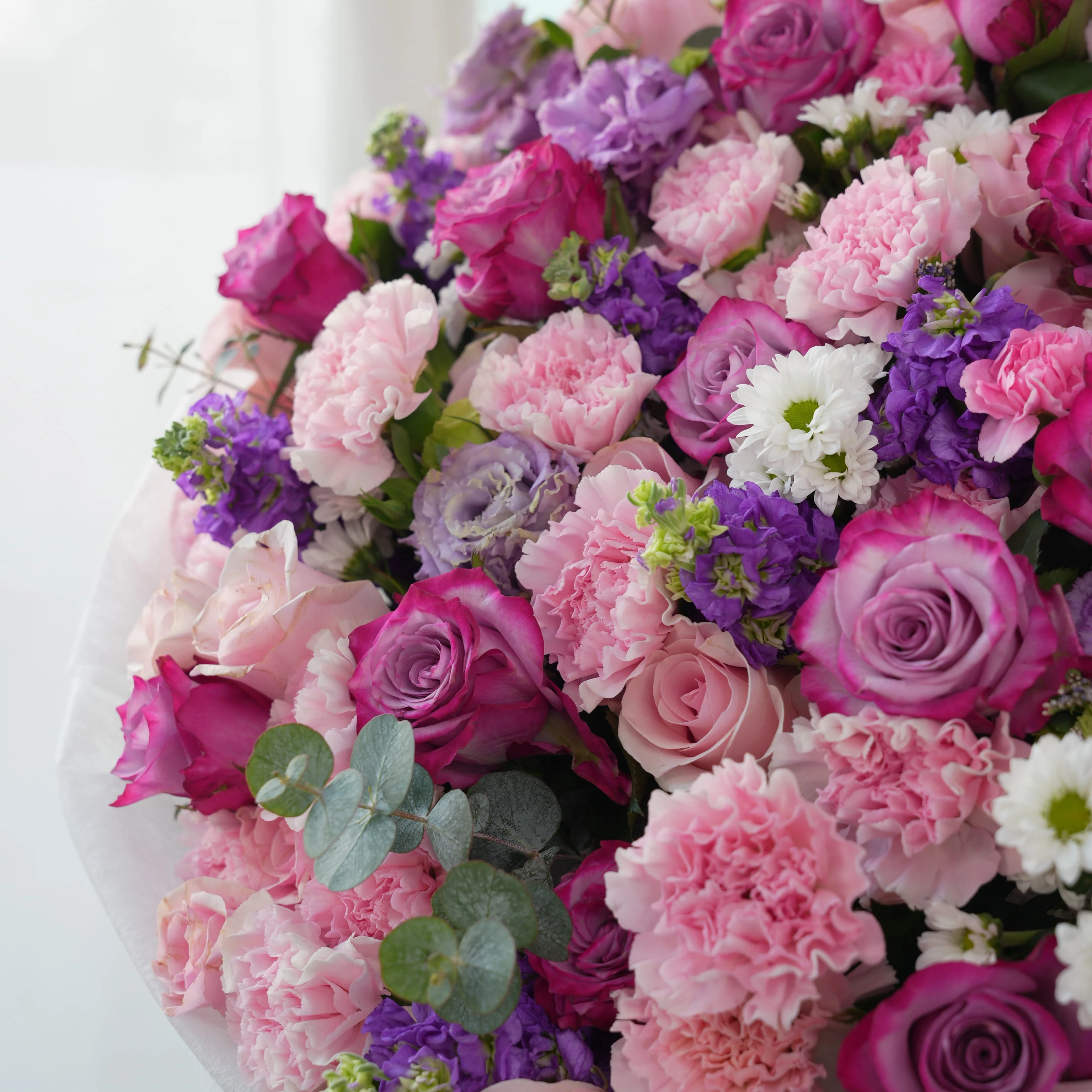 Bouquet of 10 purple matthiola, 10 white chrysanthemums, 10 purple lisianthus, 30 pink carnations, 20 purple roses and 40 pink roses with green fillers in nice wrapping.