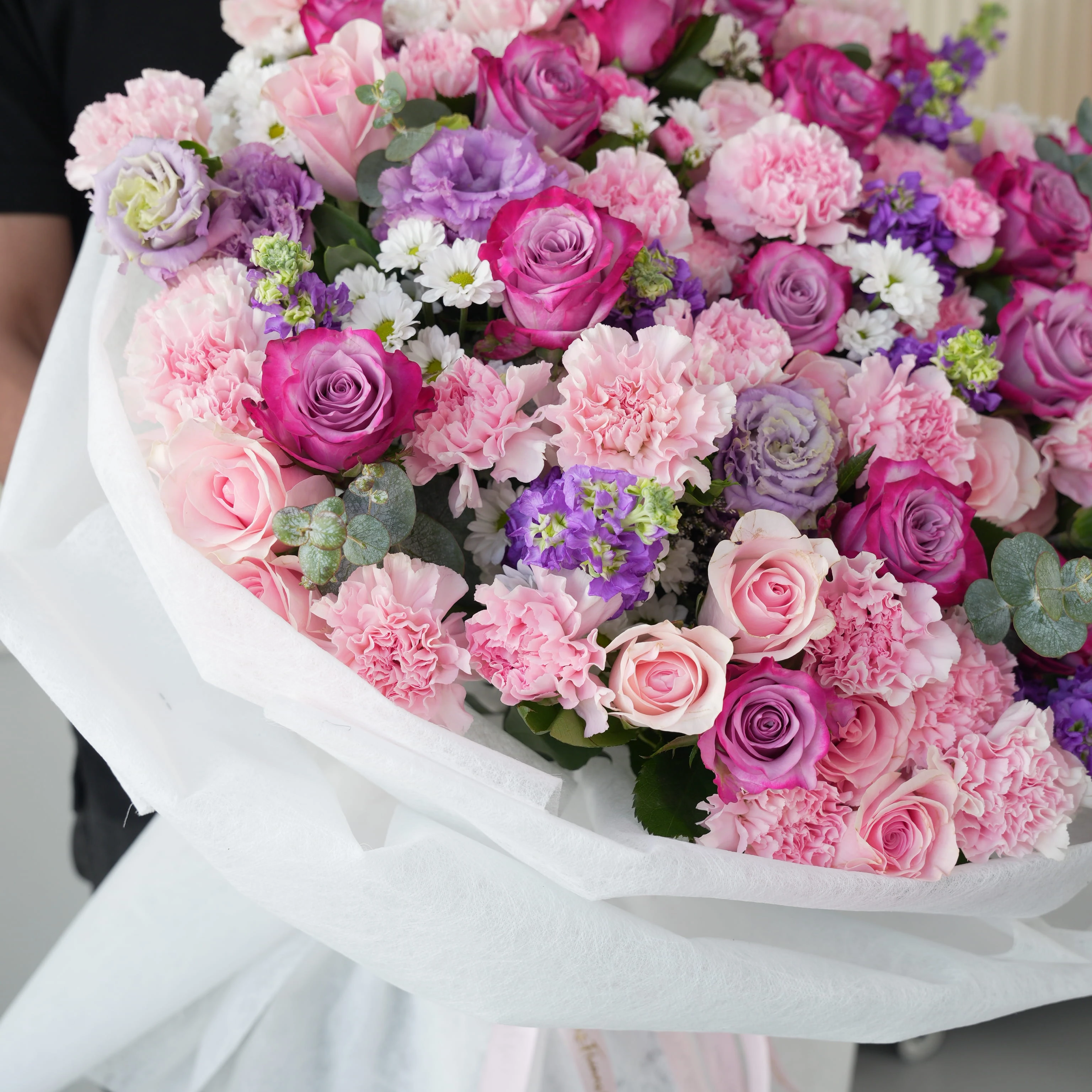 Bouquet of 10 purple matthiola, 10 white chrysanthemums, 10 purple lisianthus, 30 pink carnations, 20 purple roses and 40 pink roses with green fillers in nice wrapping.