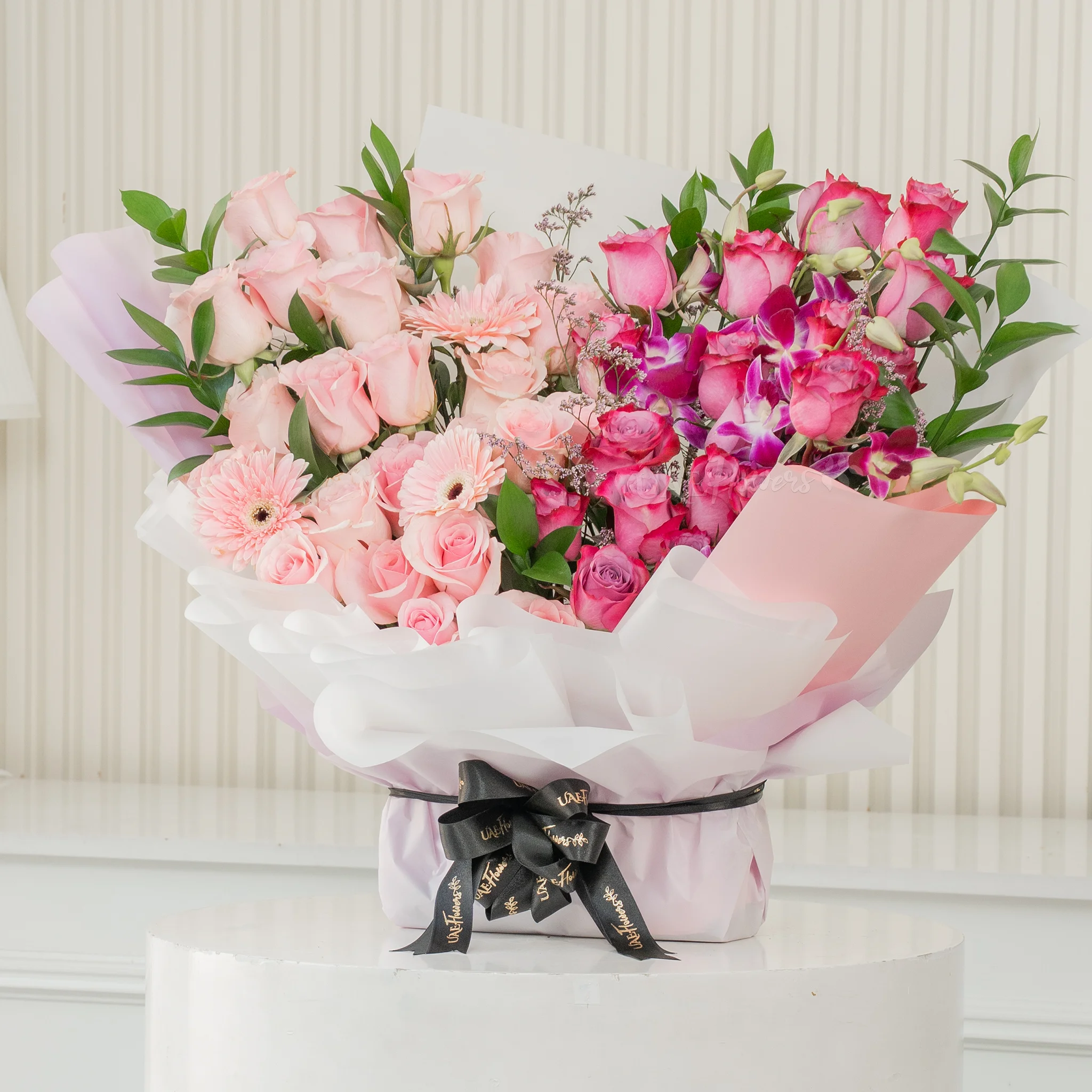 Bouquet of 20 purple roses, 20 pink roses, 6 purple orchids and 3 pink gerberas with fillers in a nice wrapping paper.