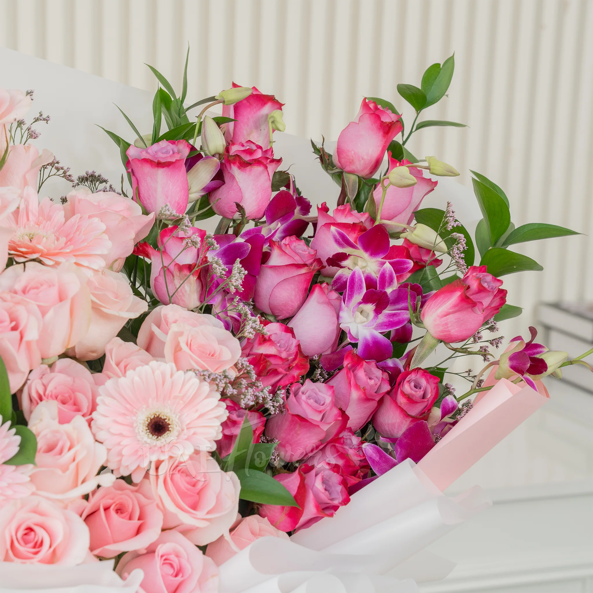 Bouquet of 20 purple roses, 20 pink roses, 6 purple orchids and 3 pink gerberas with fillers in a nice wrapping paper.