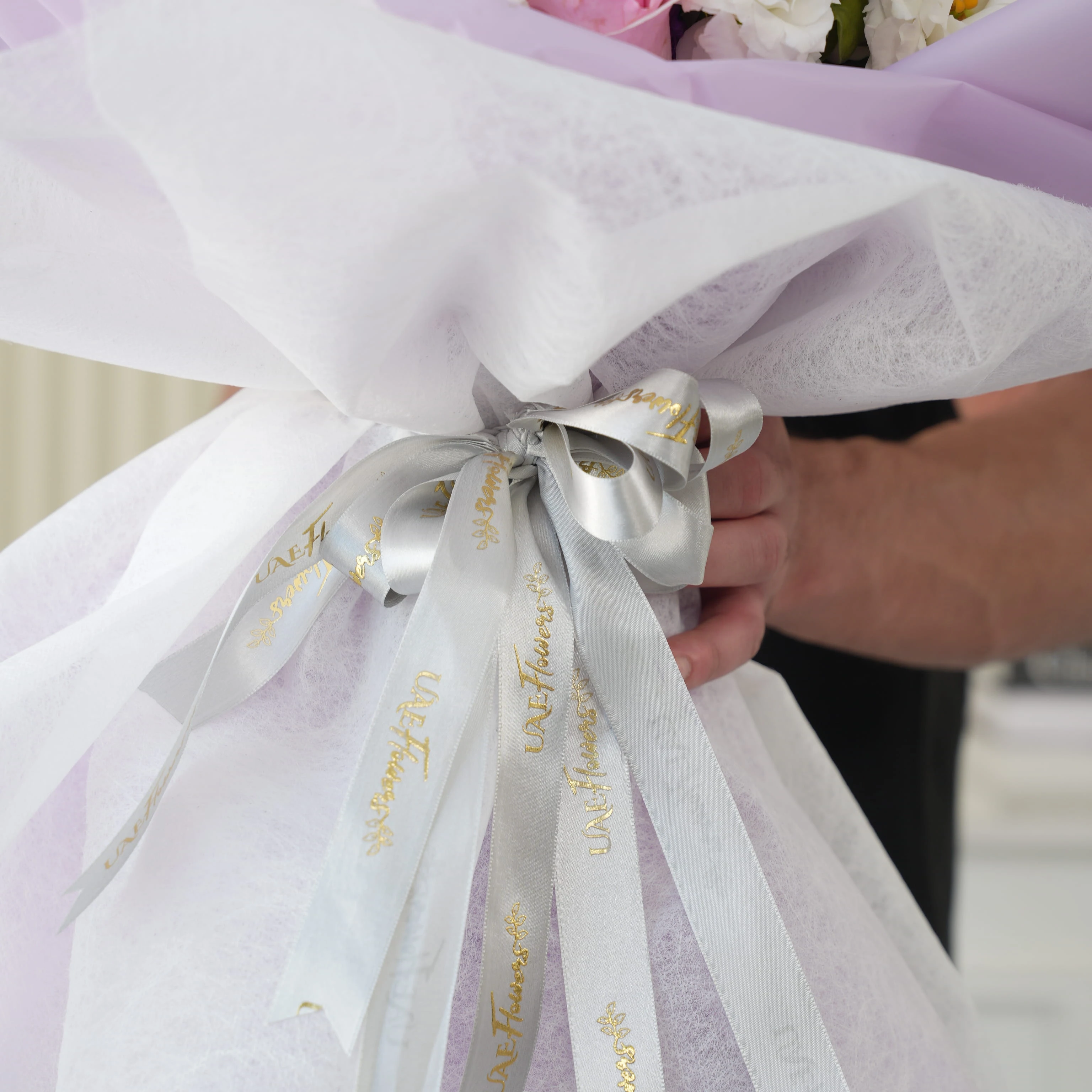 Bouquet of 2 white lilies, 10 purple matthiola, 5 white lisianthus and 8 pink roses with green fillers in nice wrapping.