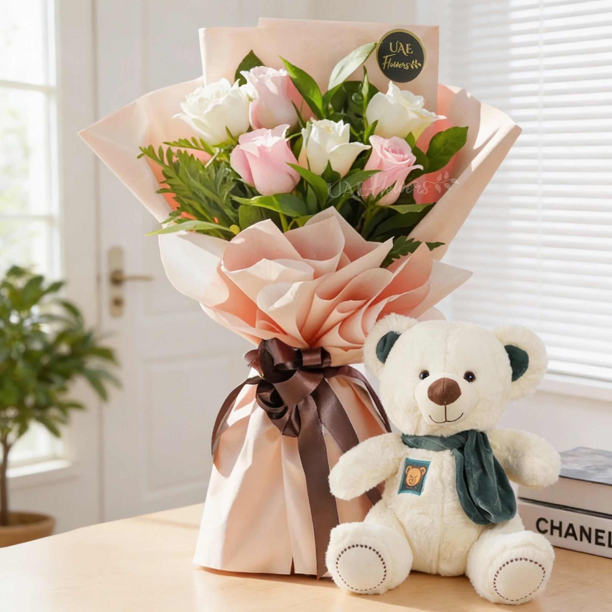 Bouquet of 6 pink & white roses with green fillers in pink paper packing tied with ribbons and small white teddy bear.