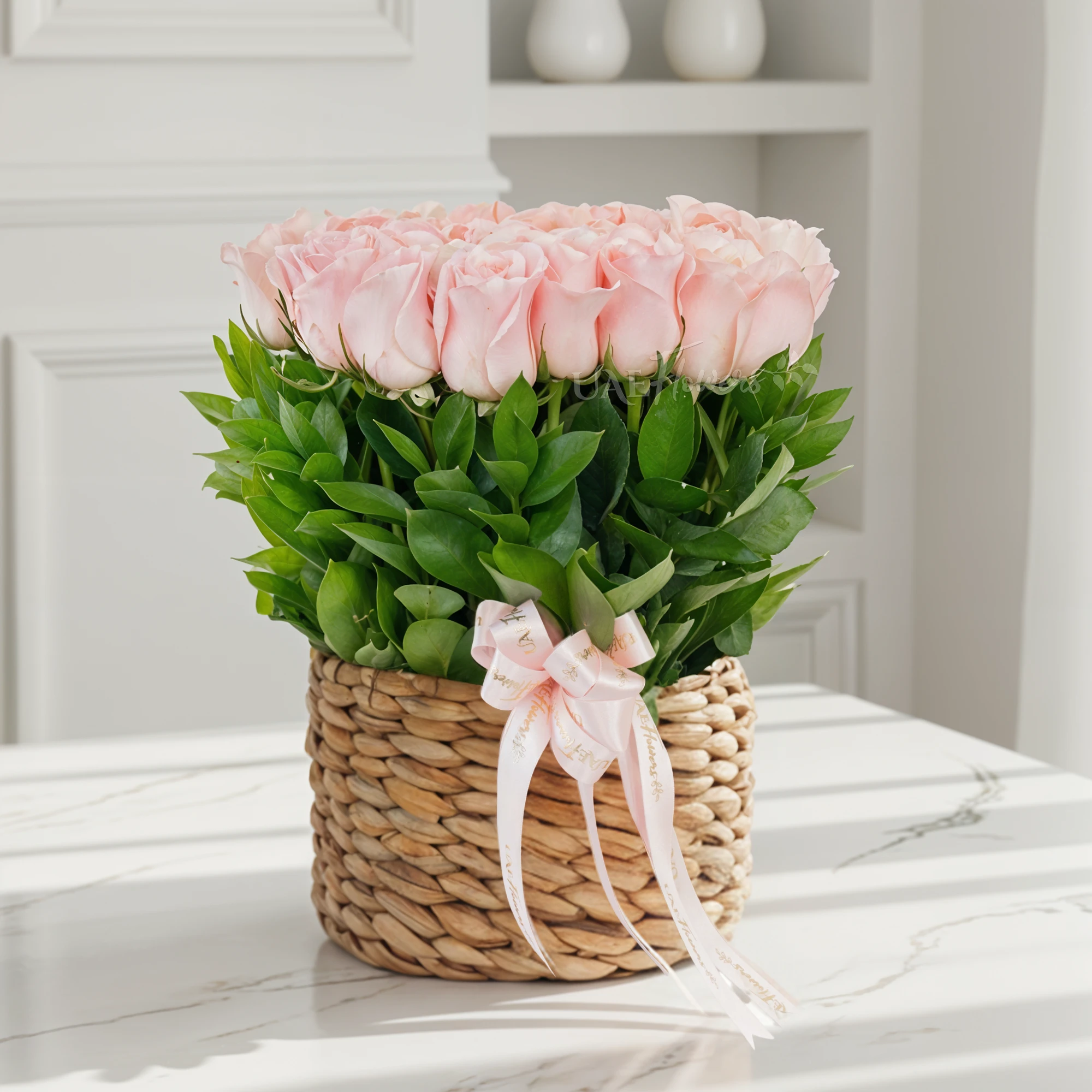 24 pink roses with green fillers in a round basket.