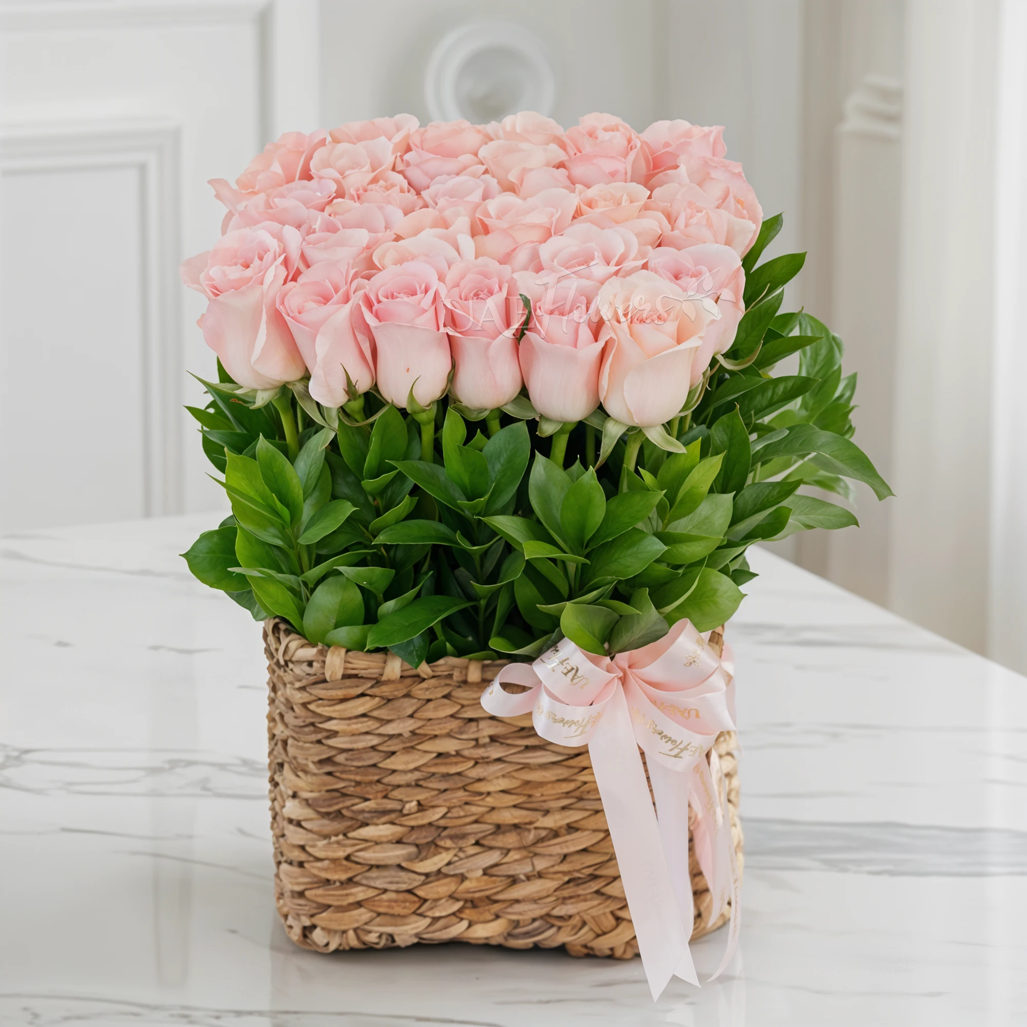 36 pink roses with green fillers in a basket.
