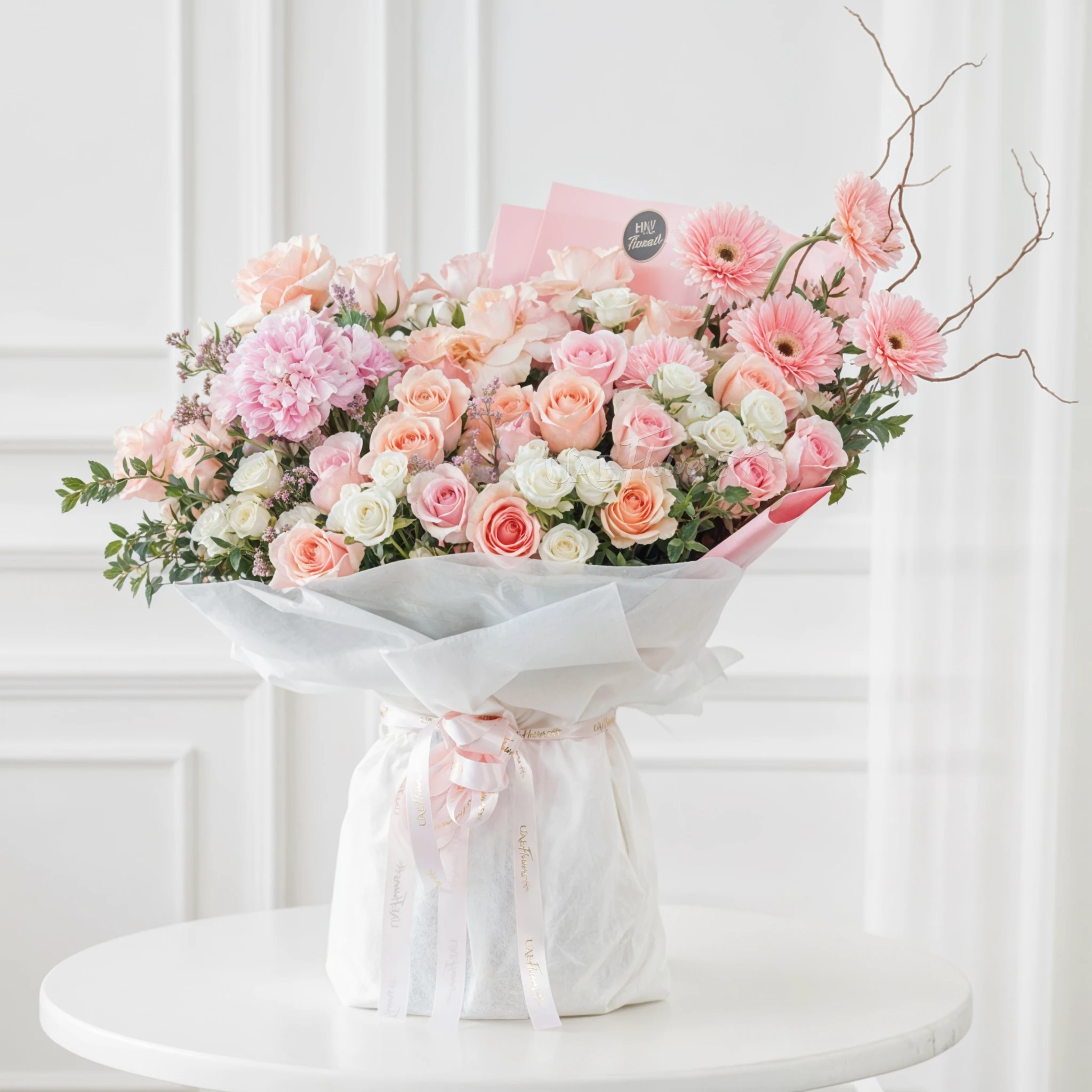 Bouquet of 25 pink roses, 5 pink gerberas, 6 white spray roses and 1 pink hydrangea with green fillers in white and pink paper packing tied with pink ribbon.