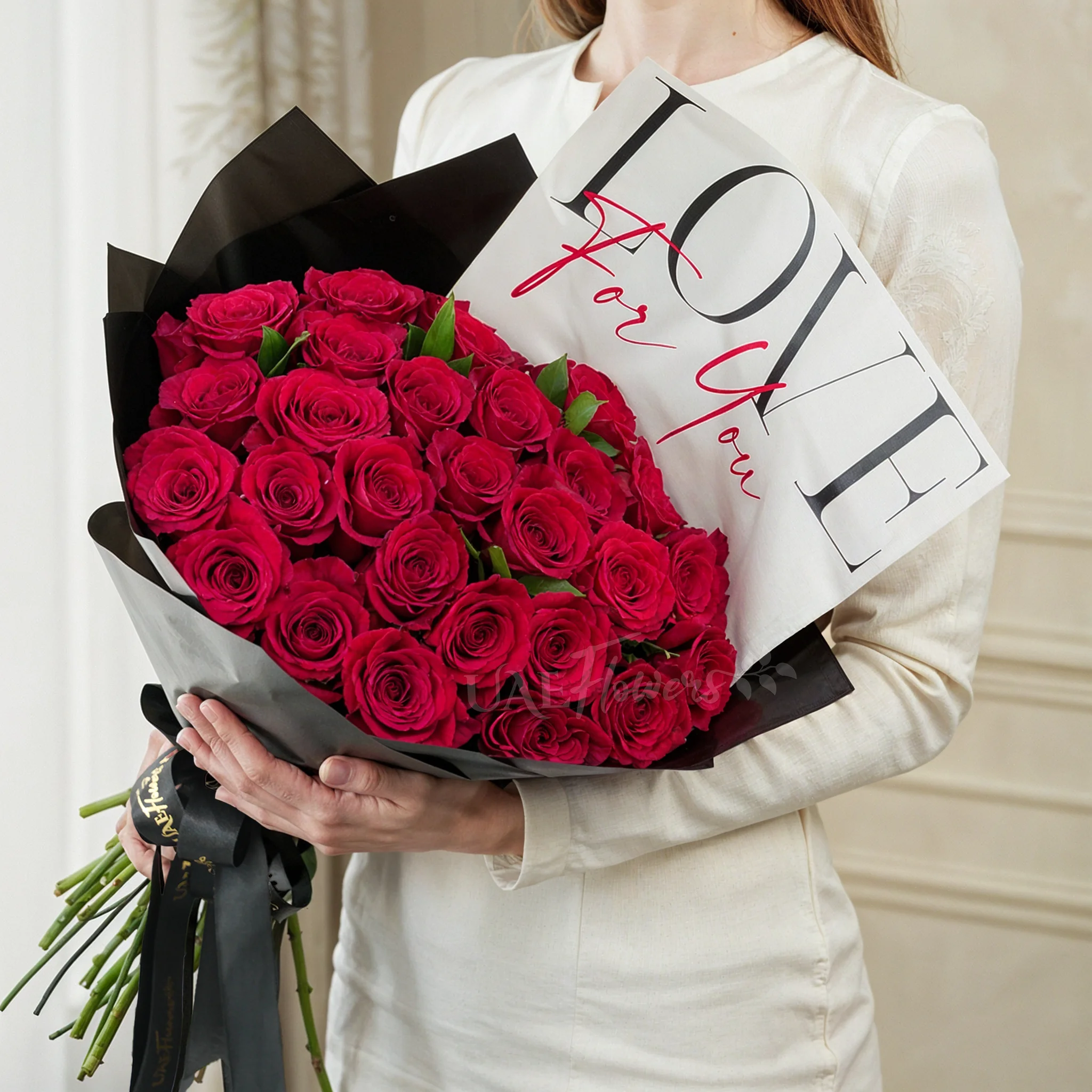 30 red roses with green fillers in black wrapping with Love For You Paper tied with black ribbons.
