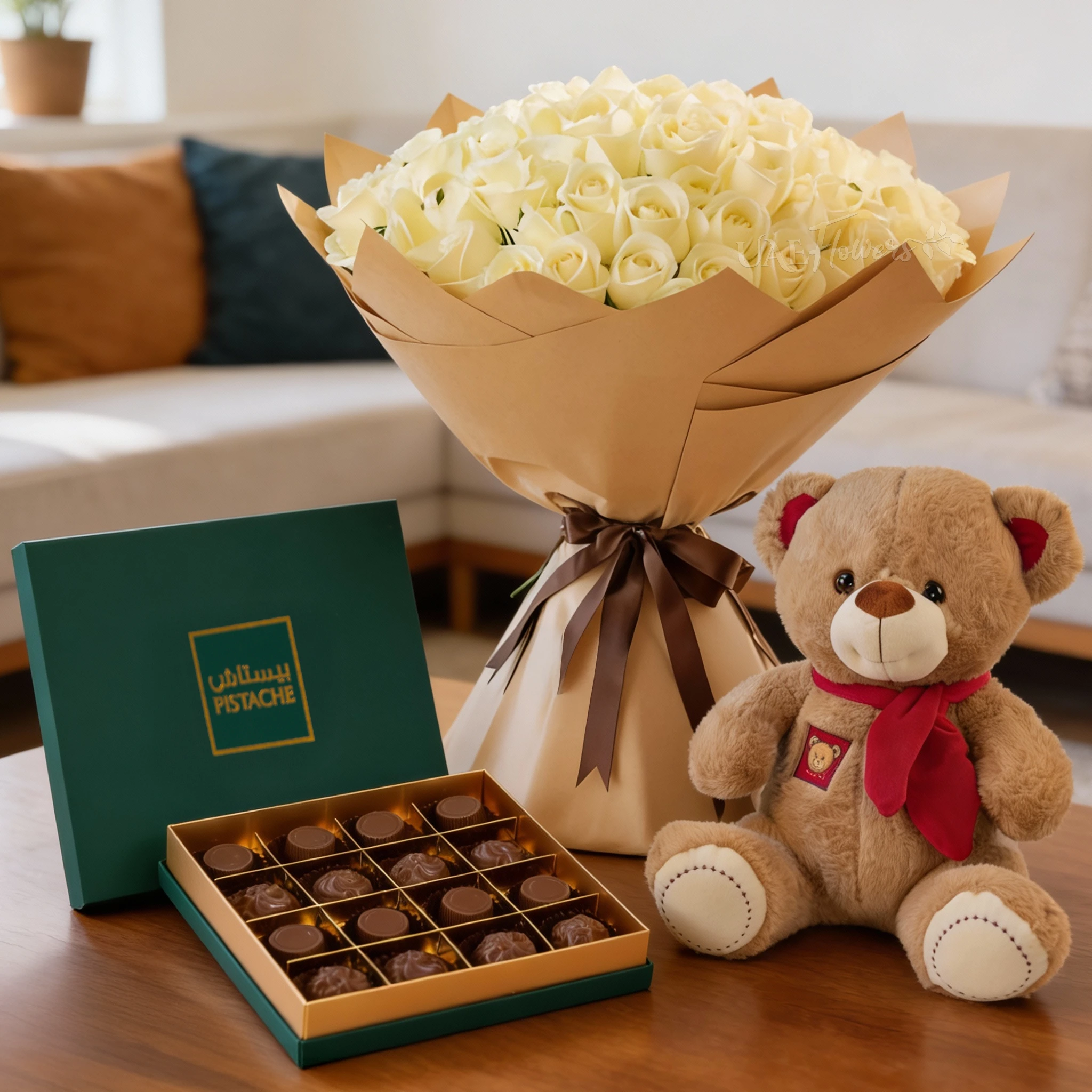 Bouquet of 100 white roses with fillers in brown wrapping, small brown teddy bear and 16 Pcs Pistache Classic Selection Chocolate Box.