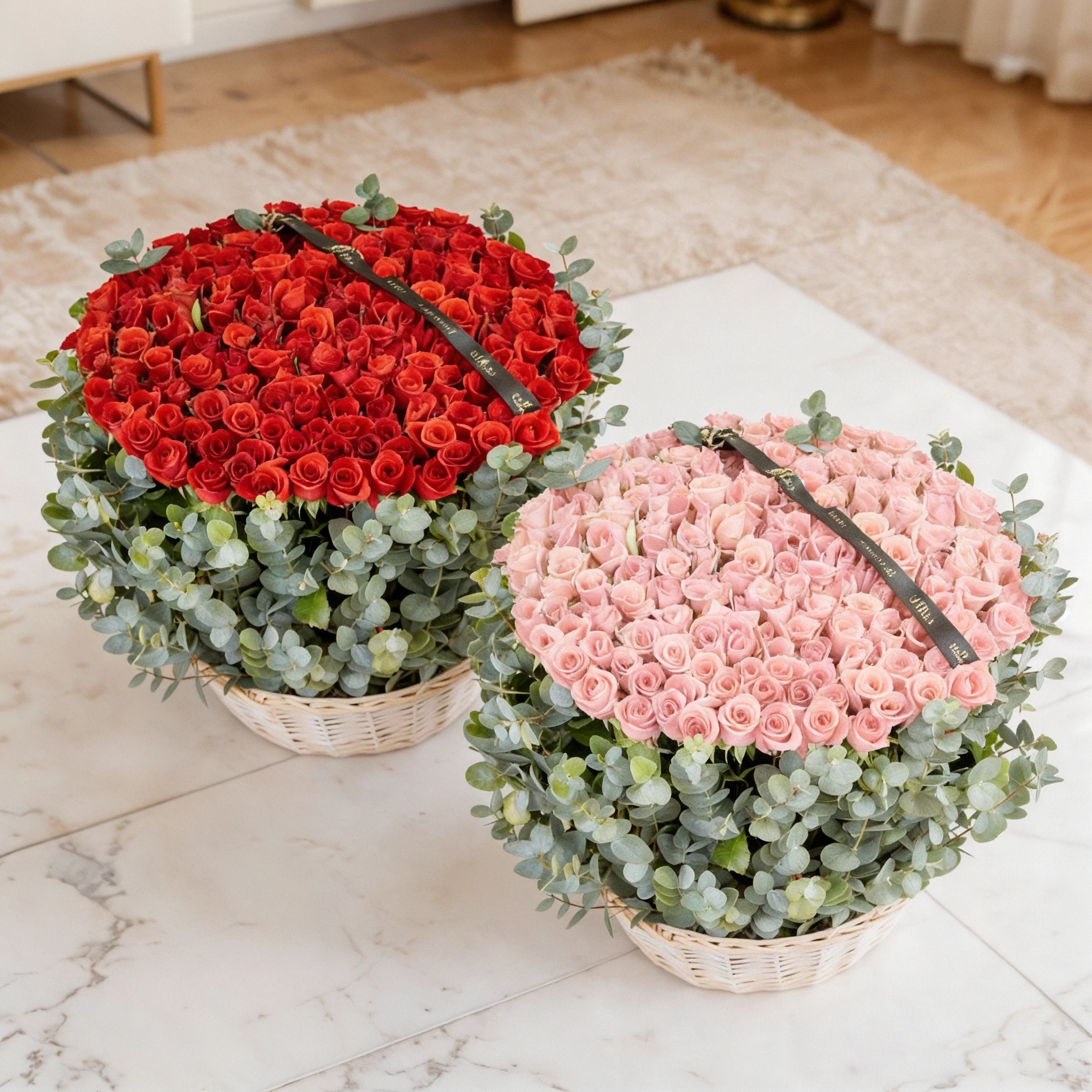 Two separate arrangements of 150 red roses and 150 pink roses, each beautifully arranged with eucalyptus leaves in a basket.