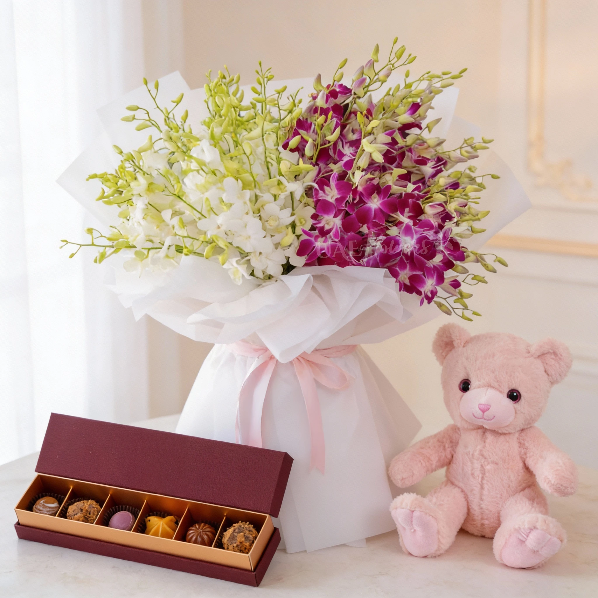 Bouquet of 40 purple & 40 white orchids with fillers in paper packing, small pink teddy bear and 6 Pcs Pistache Petite Indulgence Chocolate Box