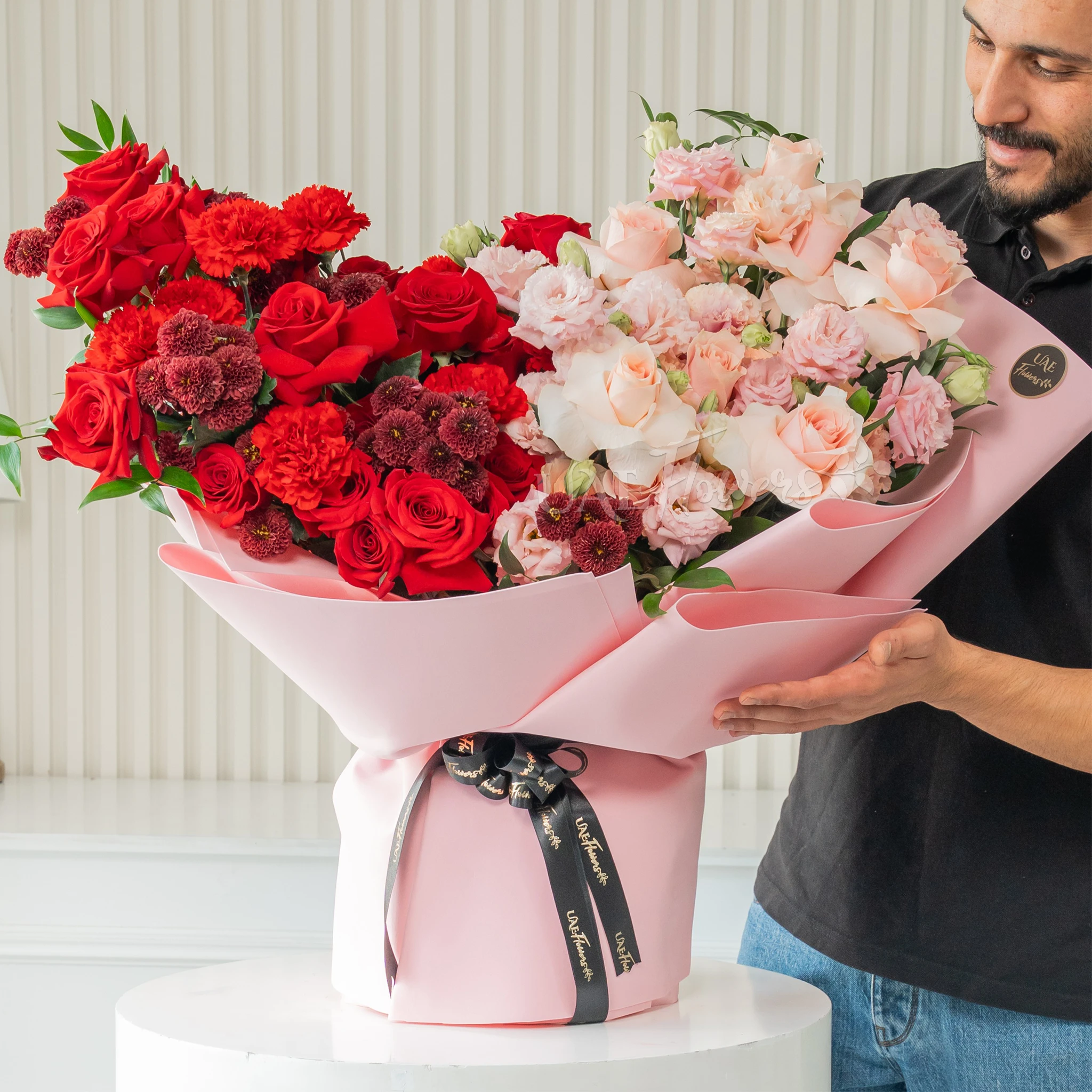 Bouquet of 20 peach roses, 5 pink lisianthus, 15 red roses, 5 red chrysanthemums and 6 red carnations with fillers in a pink wrapping paper.