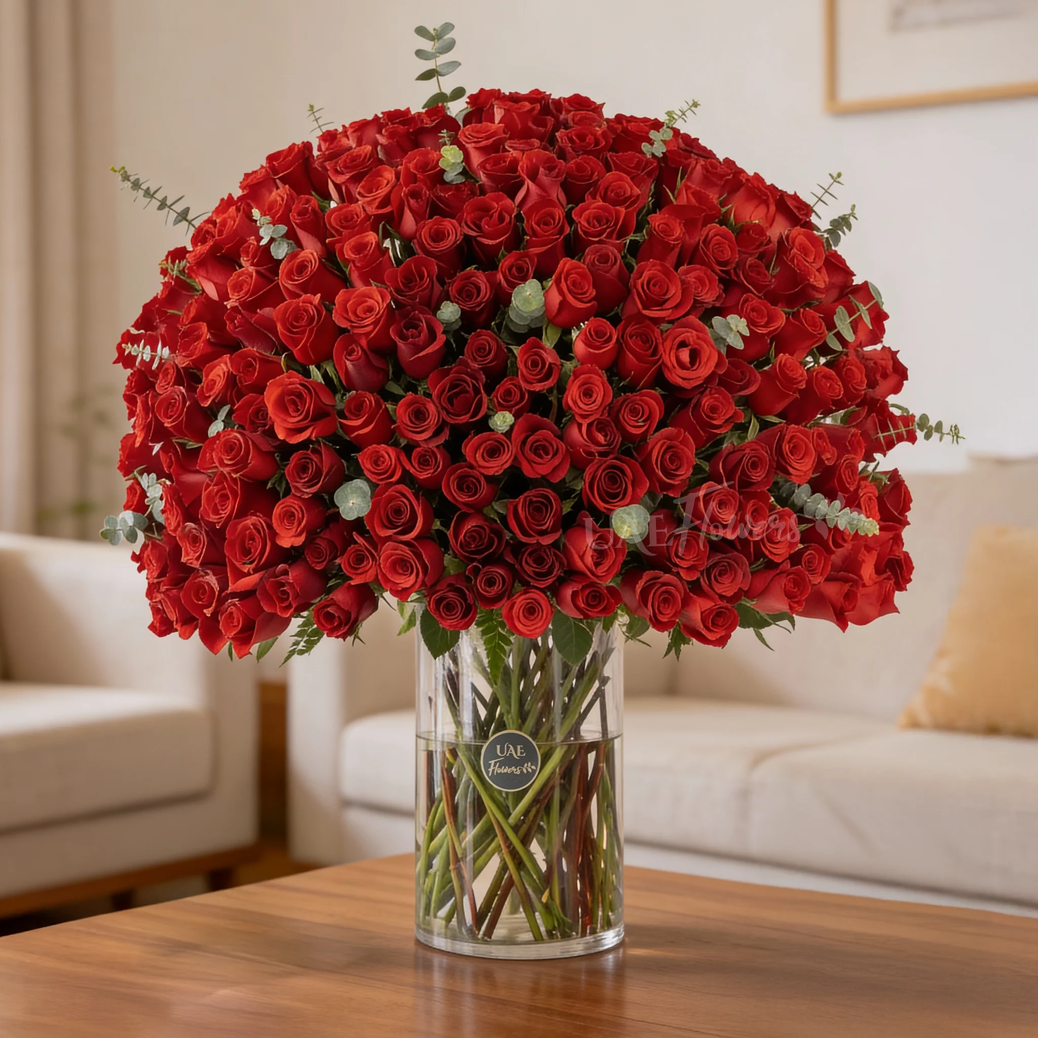200 red roses with green fillers in a glass vase.