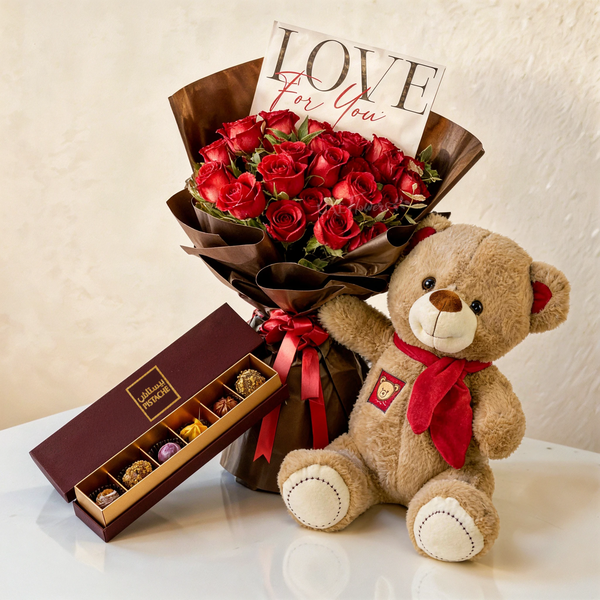 20 red roses with green fillers in black wrapping tied with red ribbons, small brown teddy bear and 6 Pcs Pistache Petite Indulgence Chocolate Box.