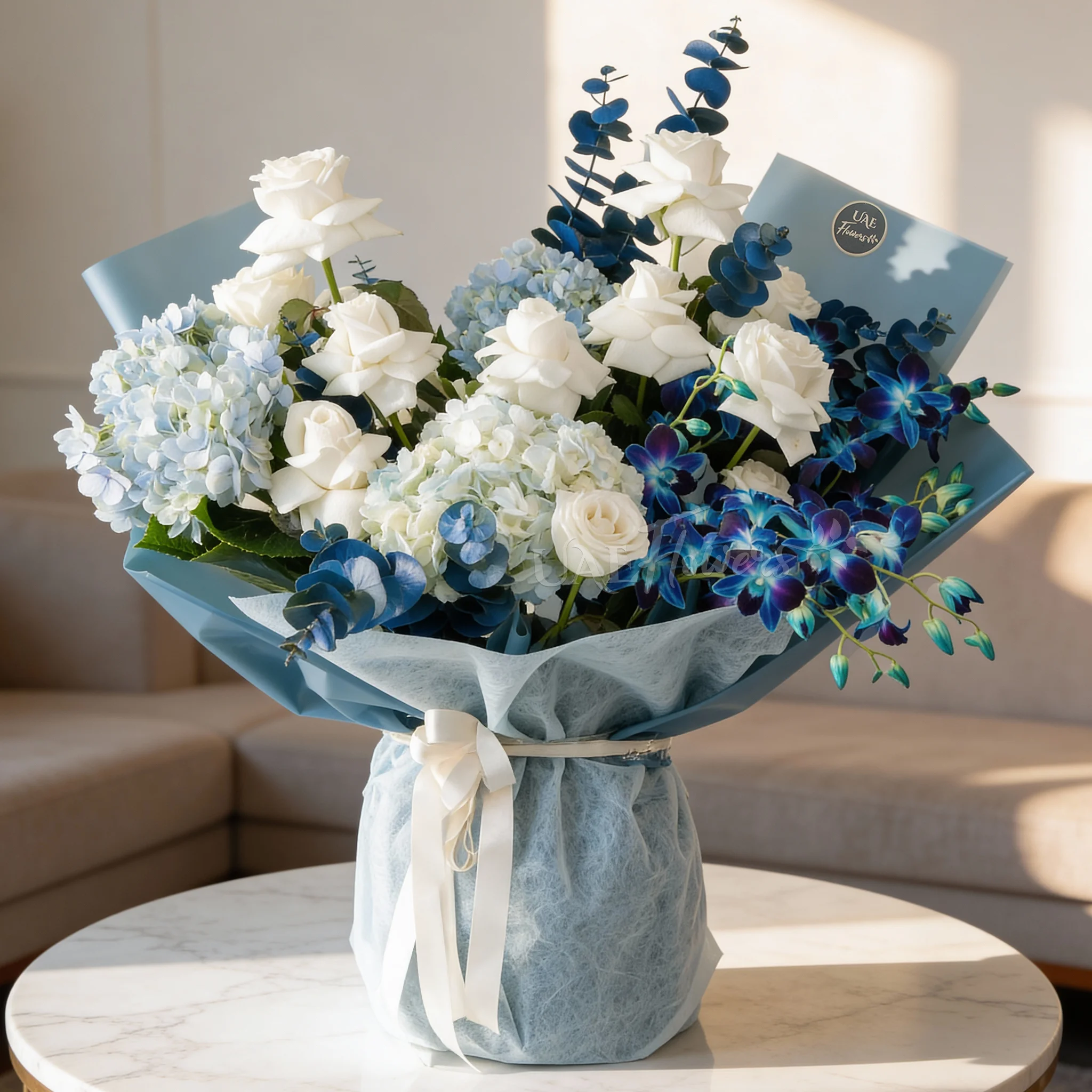 Bouquet of blue hydrangeas, white roses, and blue orchids wrapped in blue paper, a serene floral arrangement for special celebrations.