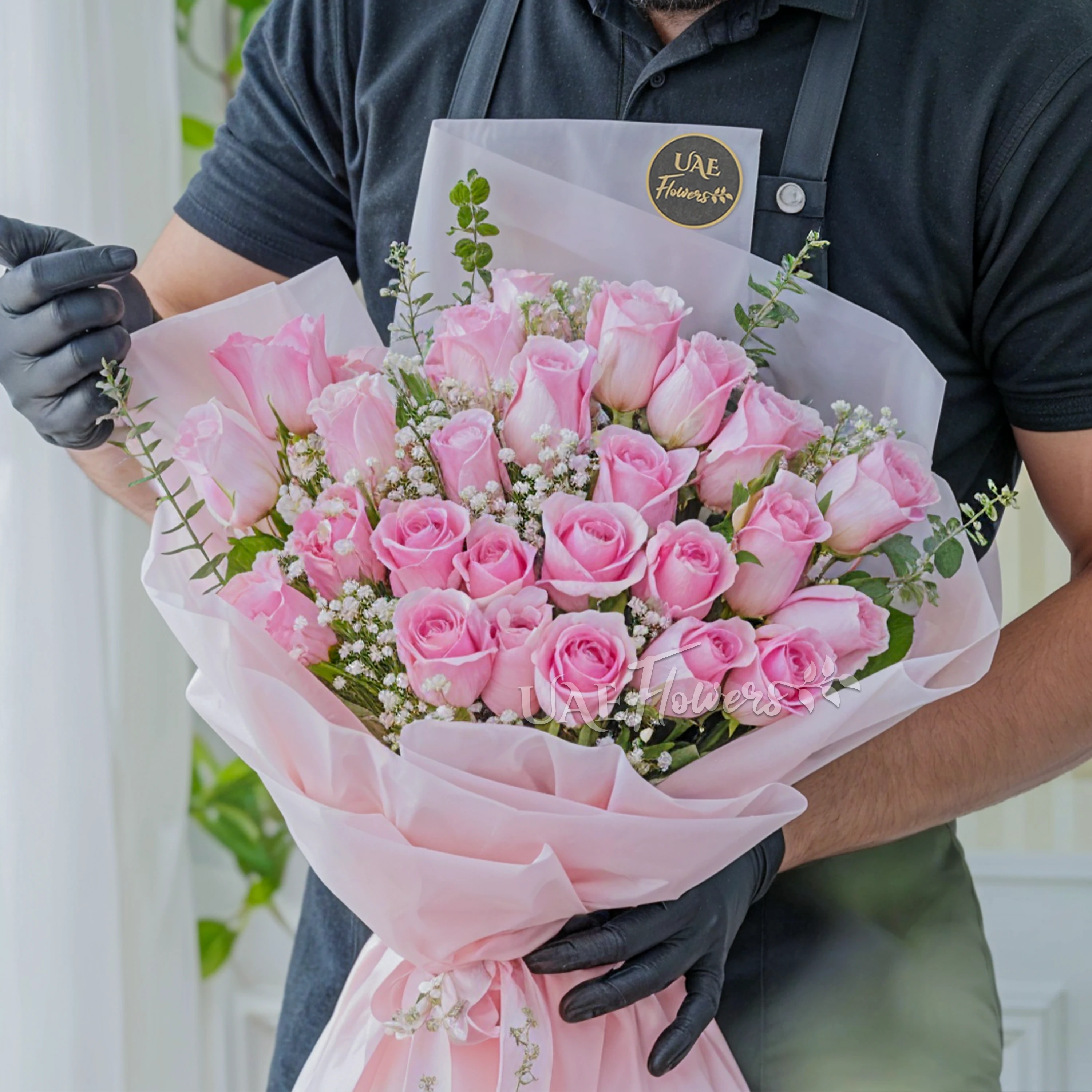 Bouquet of 24 pink roses with baby's breath & green fillers in a pink wrapping paper.