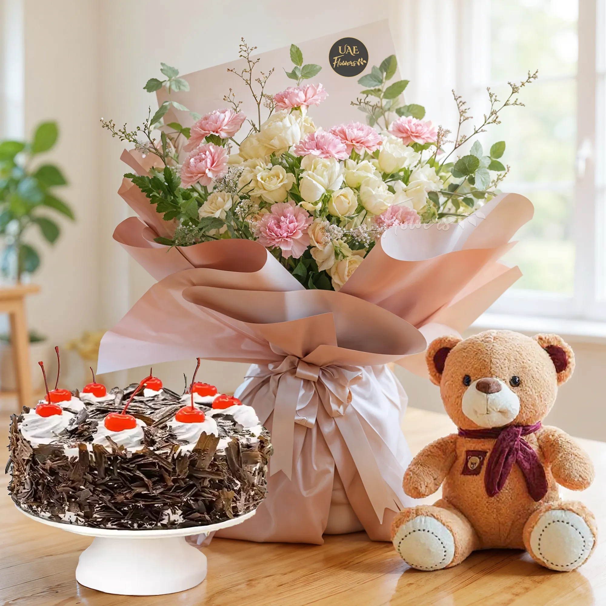 Bouquet of 8 pink carnations, 5 peach spray roses with green fillers in paper packing with ribbons, 1 kg black forest cake and a small brown teddy bear.