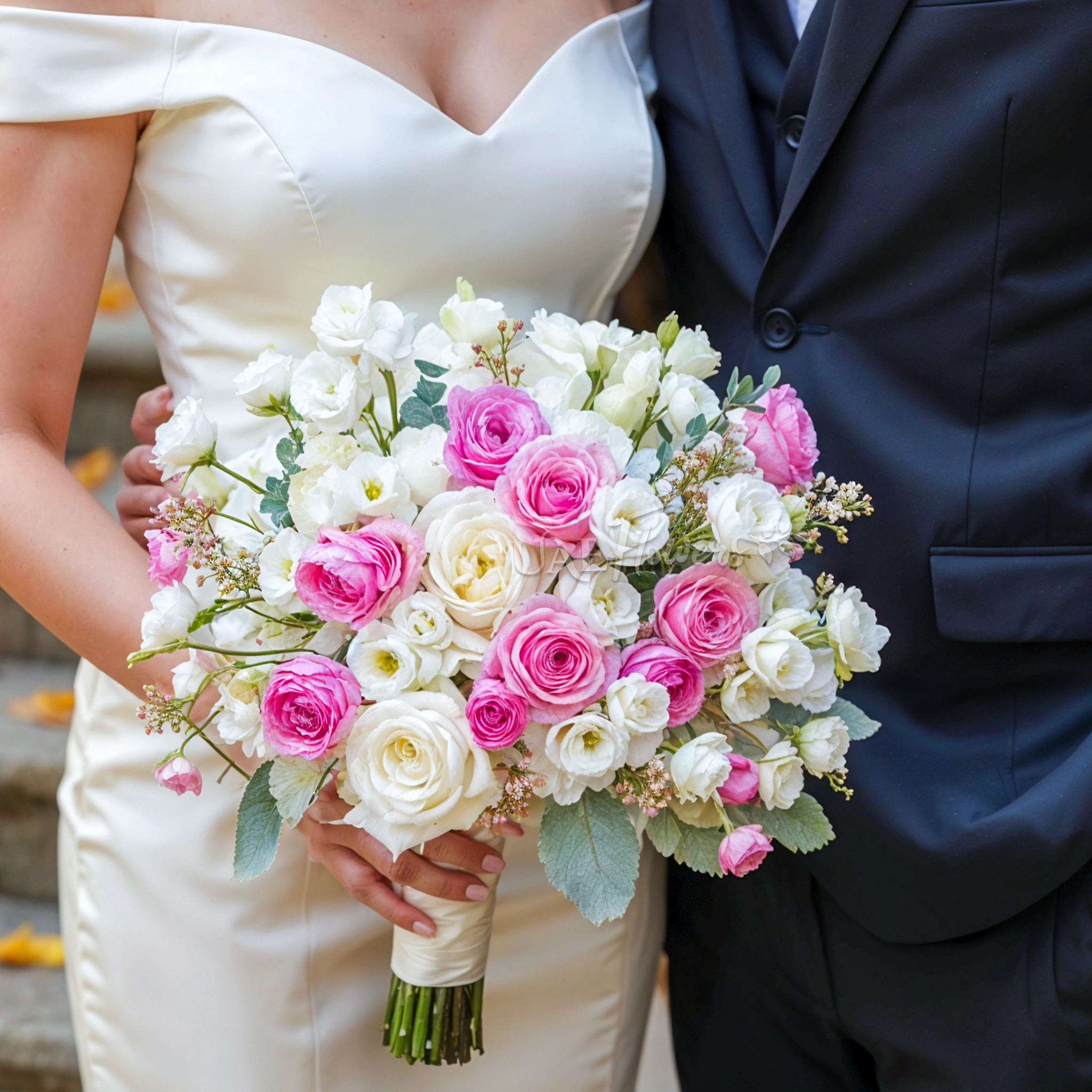 Bridal hand-tied bouquet of 10 white lisianthus, 5 pink ranunculus, 12 pink and white roses and wax flowers with greens.