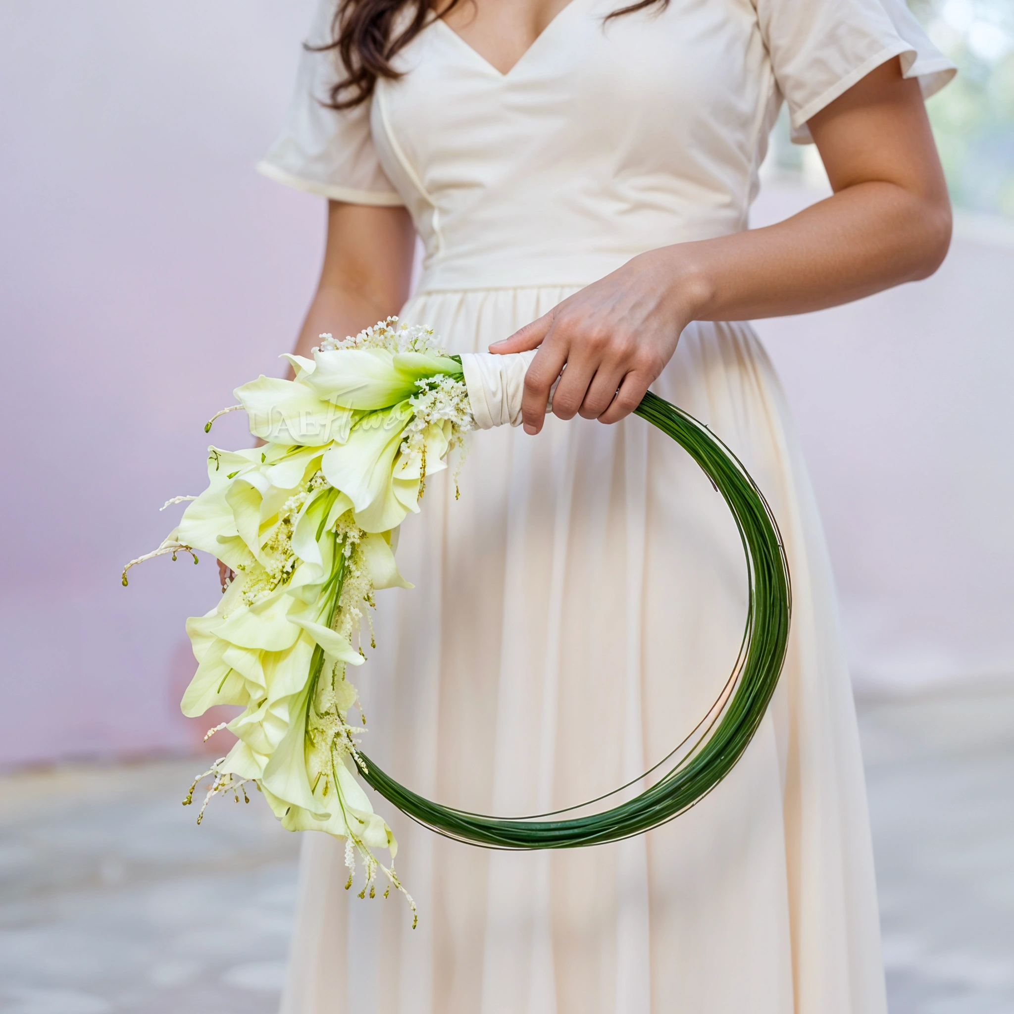 Bridal hand-tied round arrangement of 30 calla lilies and 3 bundles of steel grass.