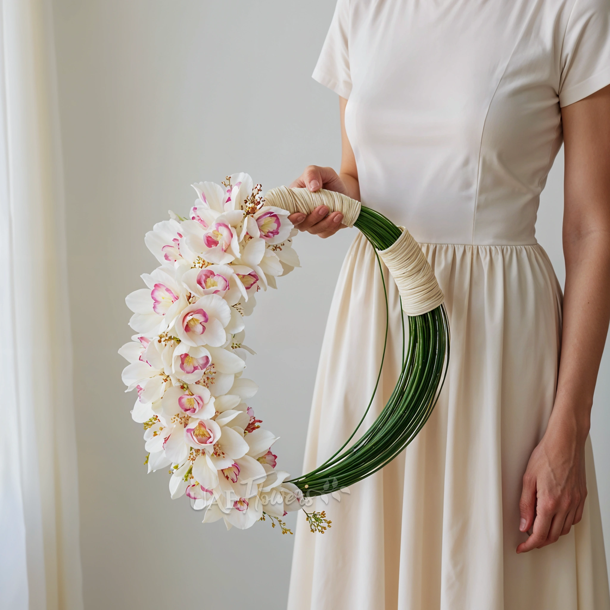 Bridal hand-tied round arrangement of 3 stems of white cymbidium orchids and 3 bundles of steel grass.