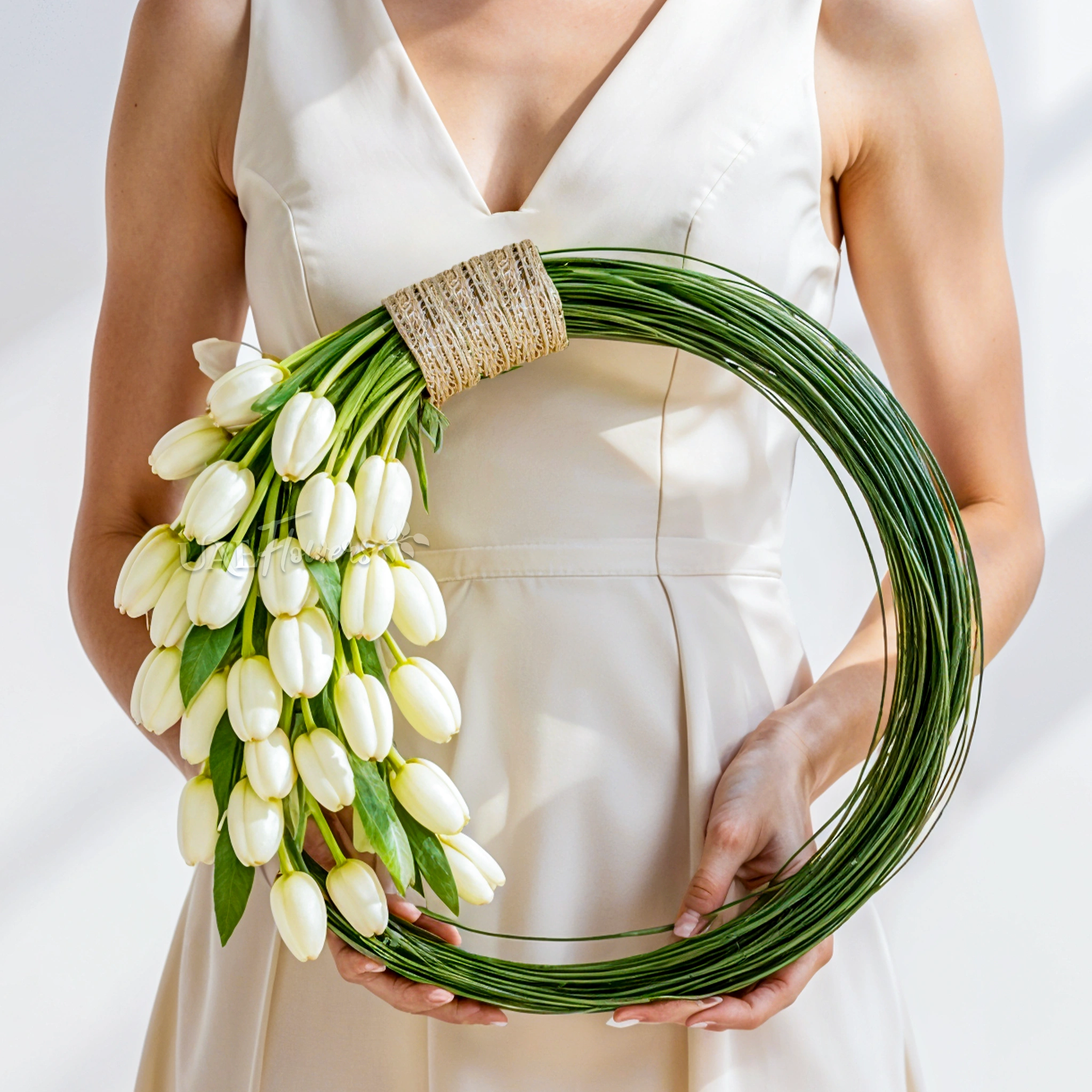 Bridal hand-tied round arrangement of 30 white tulips and 3 bundles of steel grass.