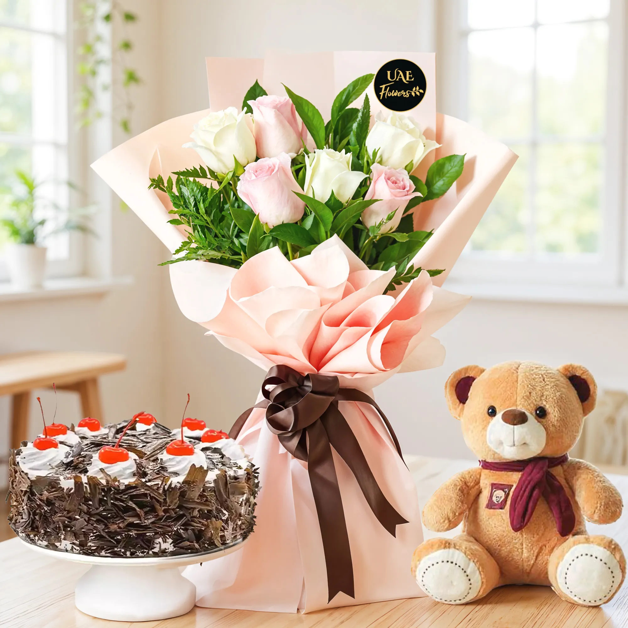 Bouquet of 6 white and pink roses with green fillers in nice wrapping, a small brown teddy bear and 1 kg black forest cake.