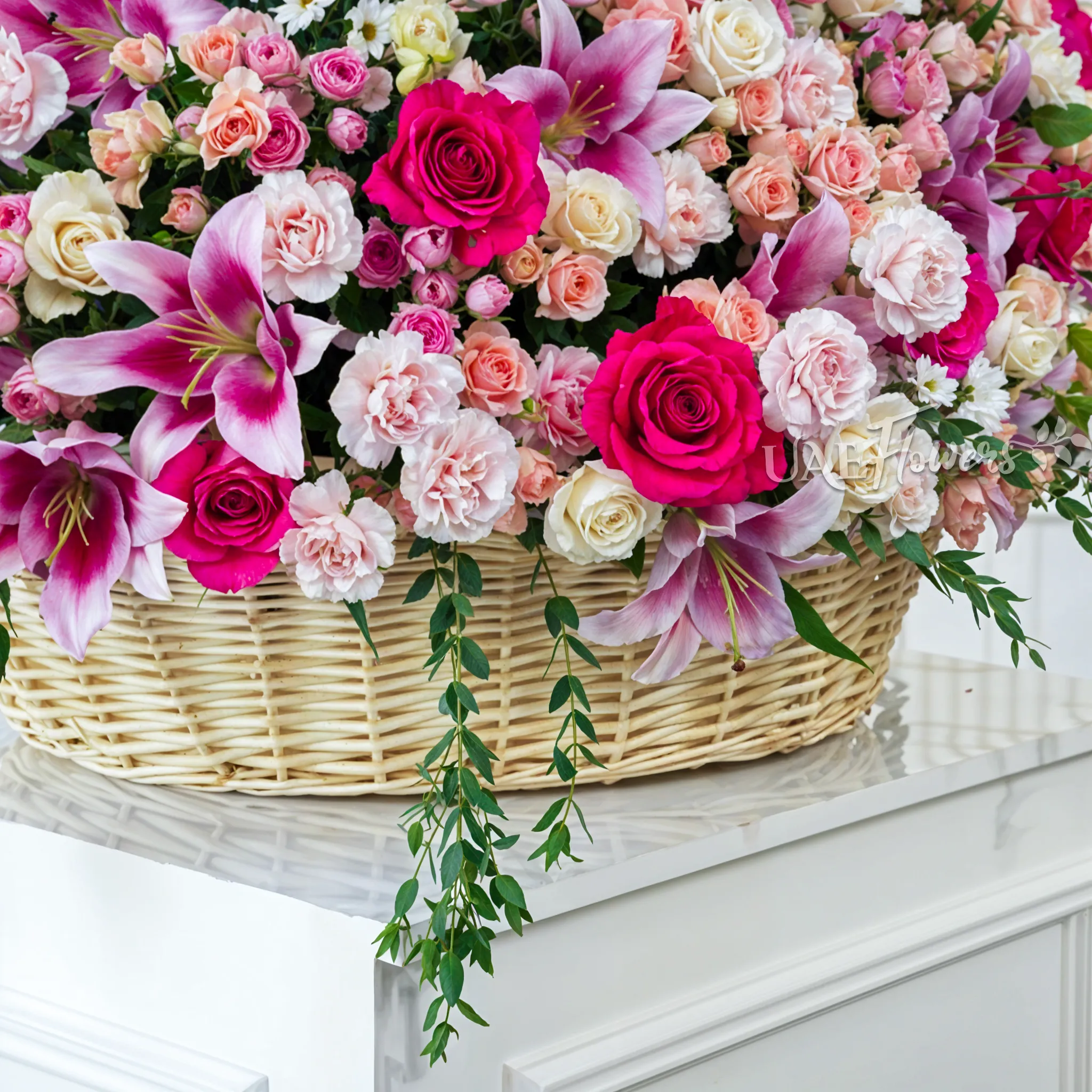 20 Pink Lilies, 50 Peach Spray Roses, 70 Carnations,70 Cream Roses,20 White Mums and 30 Fuchsia Roses arranged in a basket