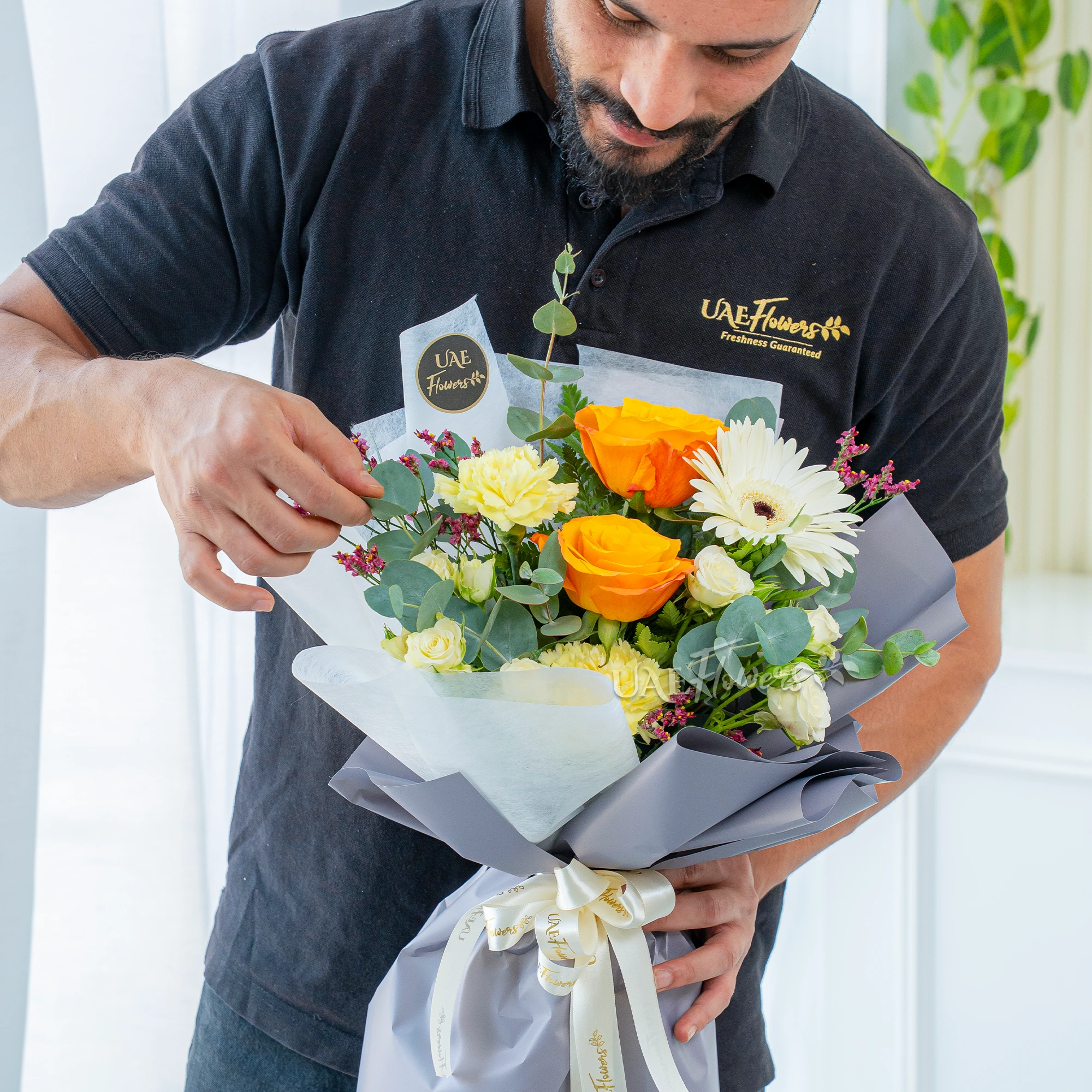 Bouquet of 2 Orange Roses, 2 Yellow Carnations, 2 white spray roses with eucalyptus leaves and limonium in nice wrapping.