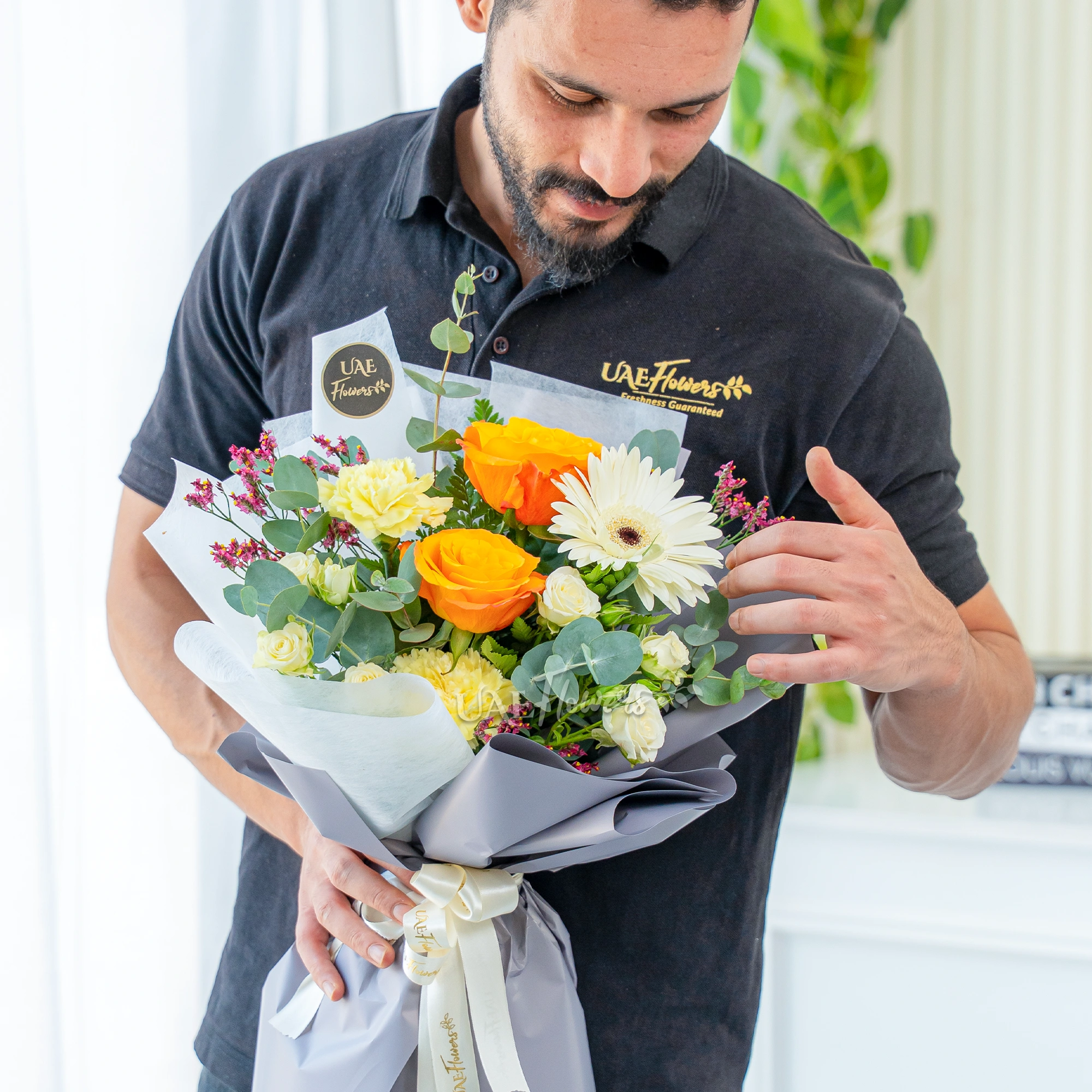 Bouquet of 2 Orange Roses, 2 Yellow Carnations, 2 white spray roses with eucalyptus leaves and limonium in nice wrapping.
