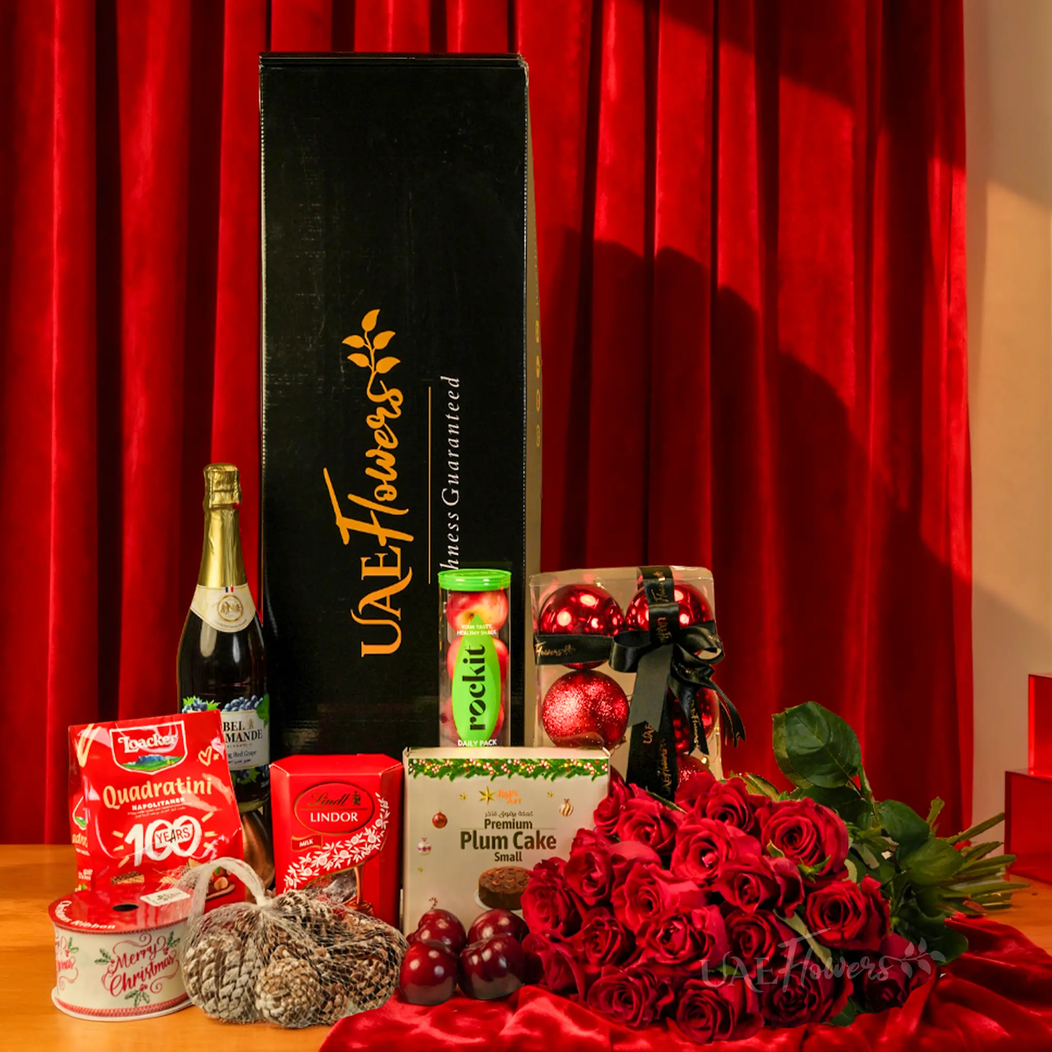 Red Christmas luxury gift box with roses, chocolates and festive treats UAE Flowers