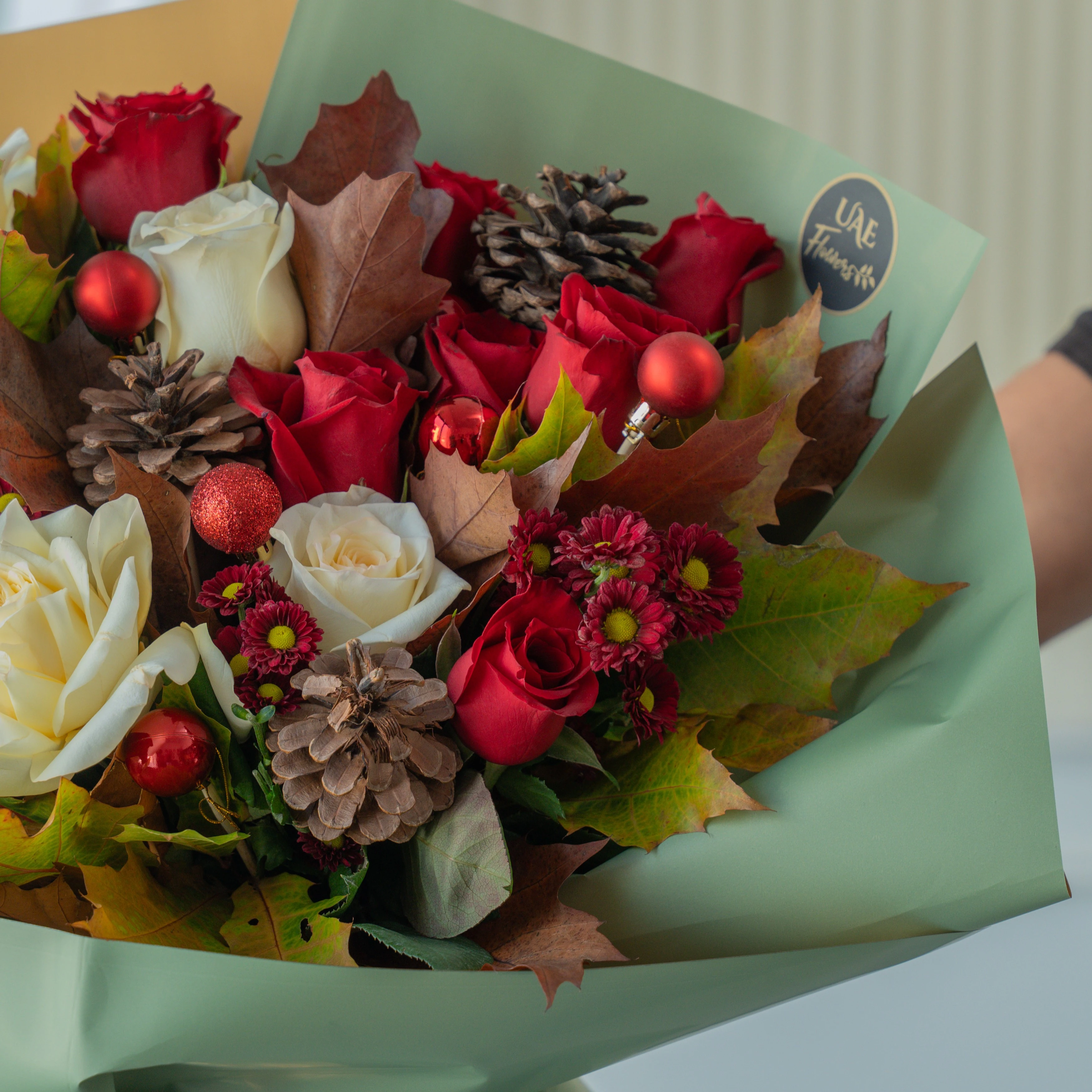 Festive red and white Christmas bouquet with pinecones and winter greens