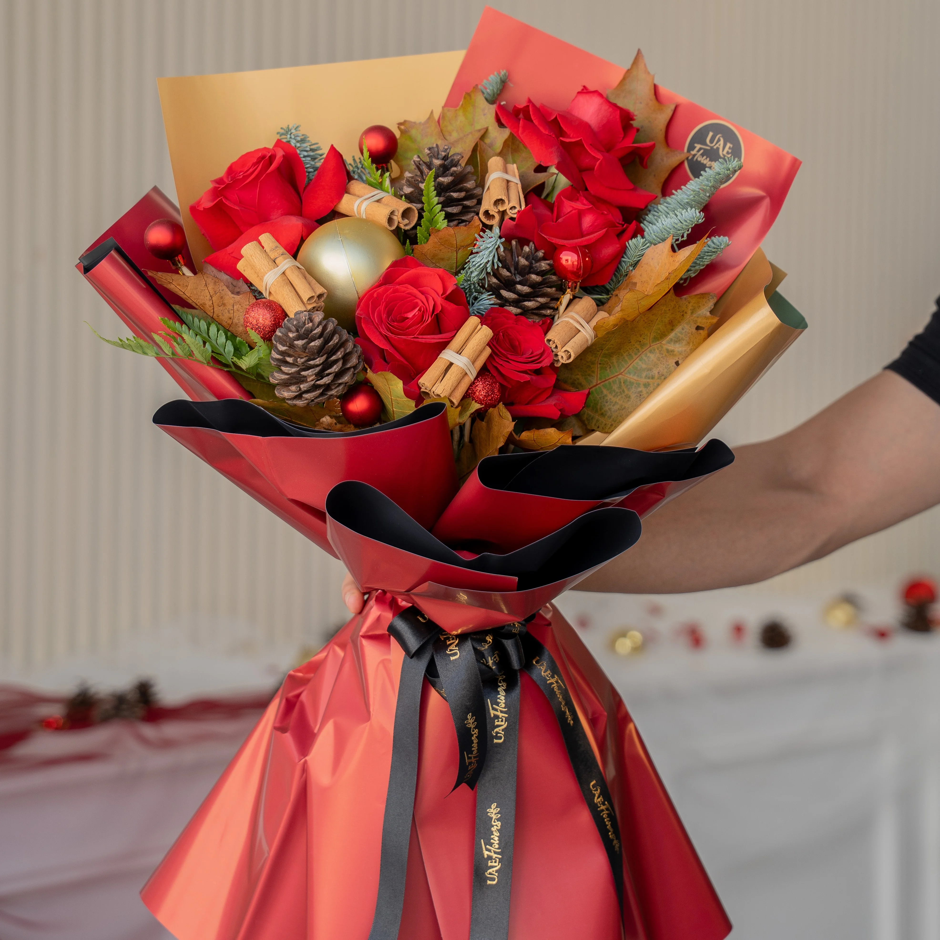 Festive red rose Christmas bouquet with pinecones and baubles