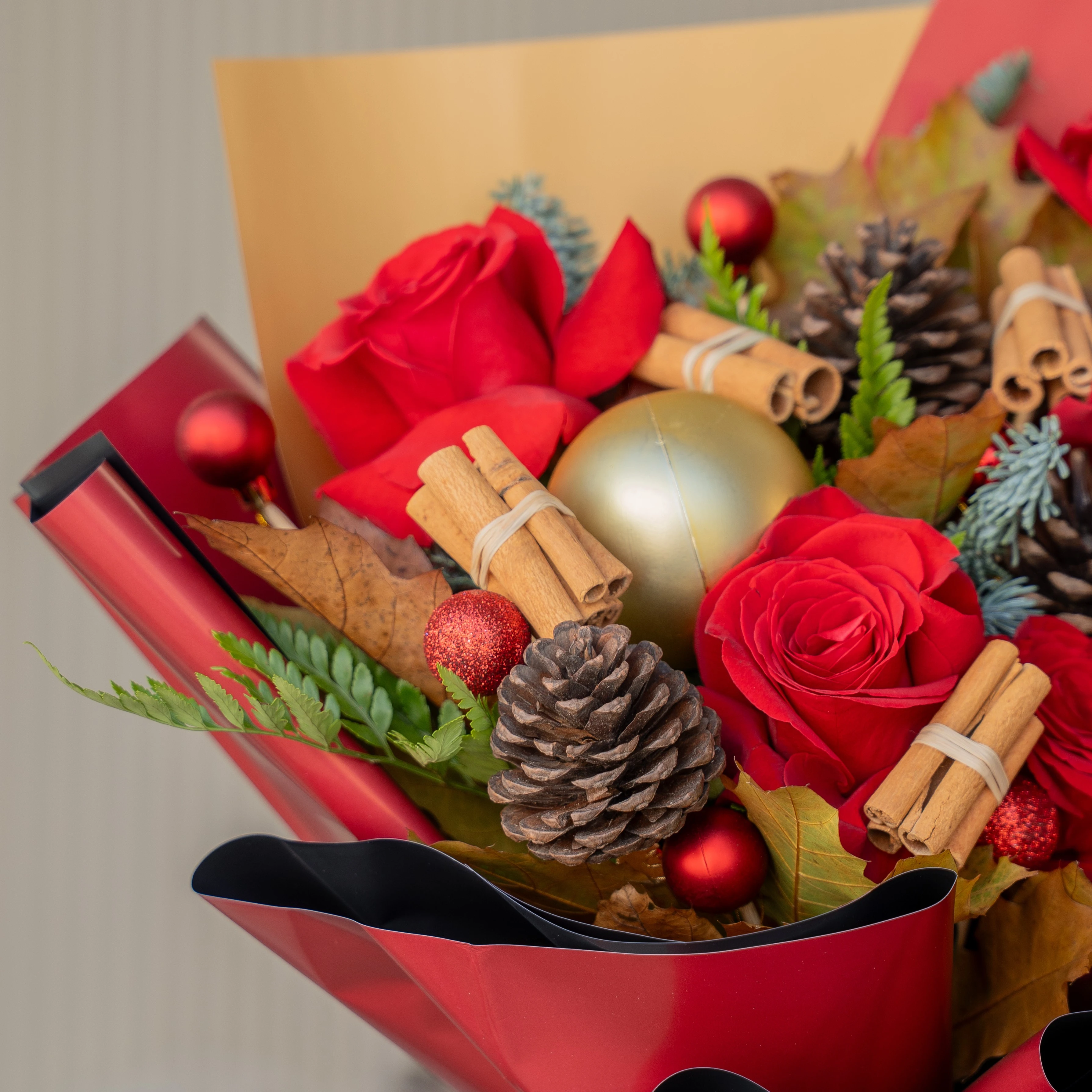 Festive red rose Christmas bouquet with pinecones and baubles