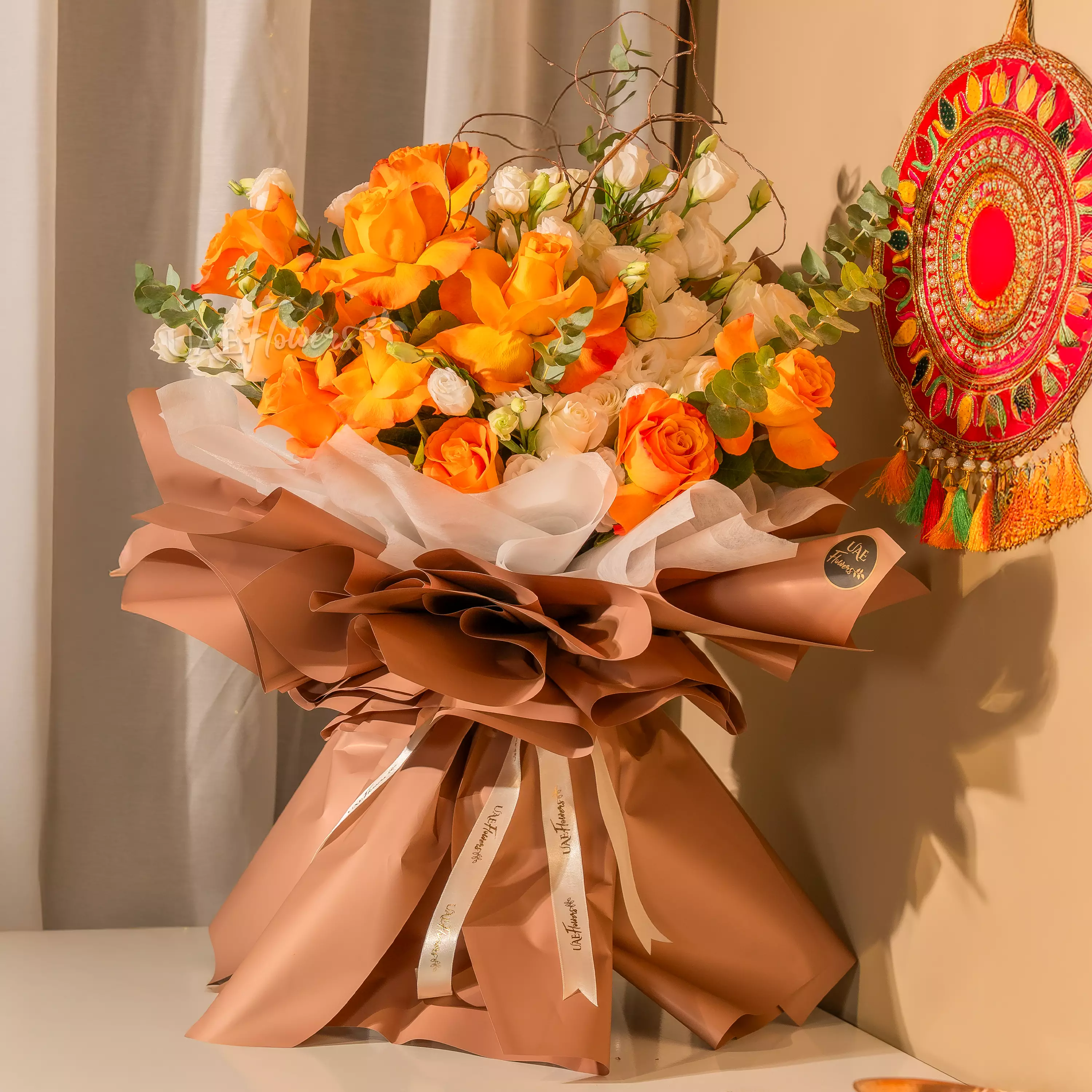 Orange and white rose bouquet with festive wrapping for Diwali by UAE Flowers Dubai