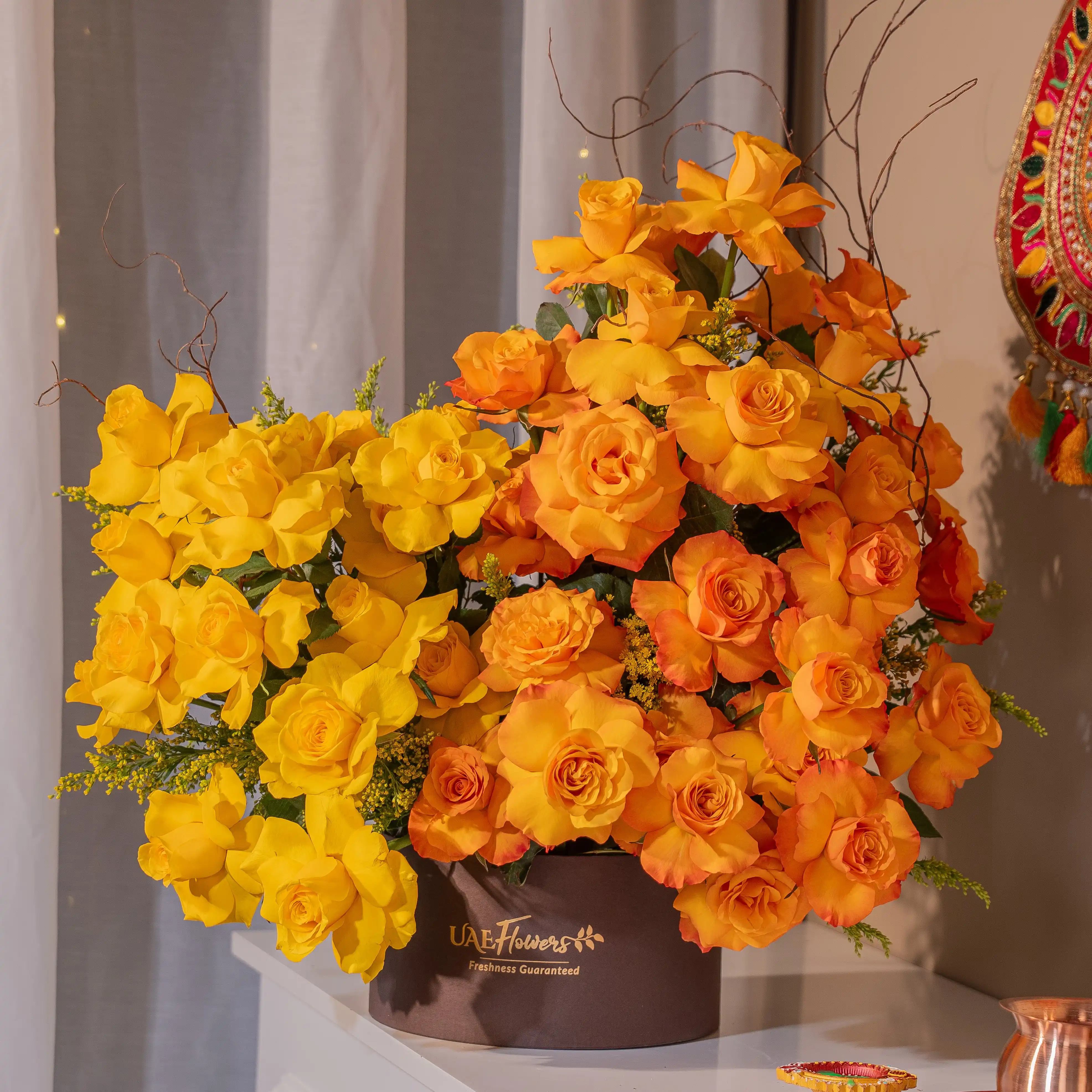 Yellow and orange roses in luxury hatbox for Diwali by UAE Flowers Dubai