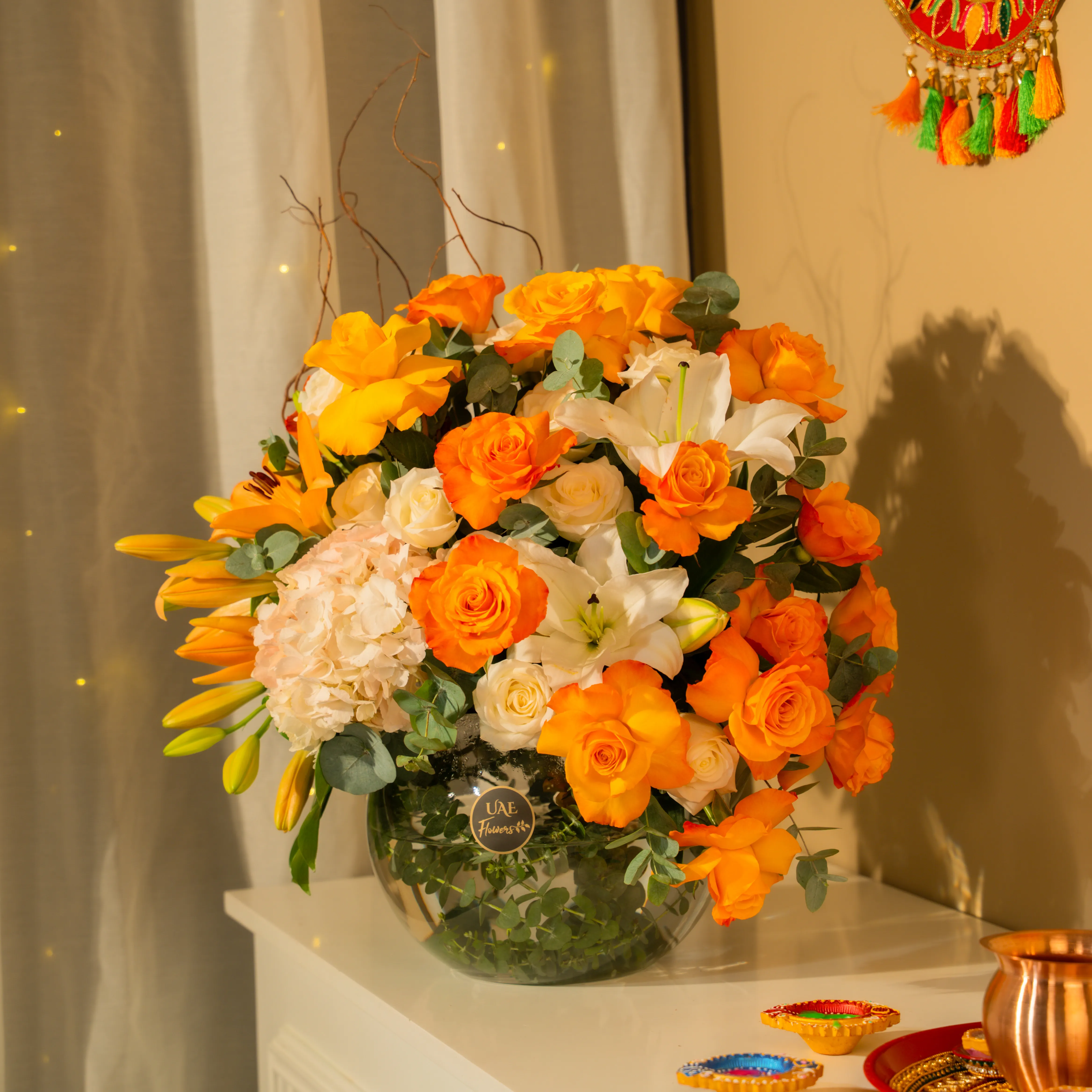 Orange roses, white lilies, and hydrangeas in glass vase for Diwali by UAE Flowers Dubai