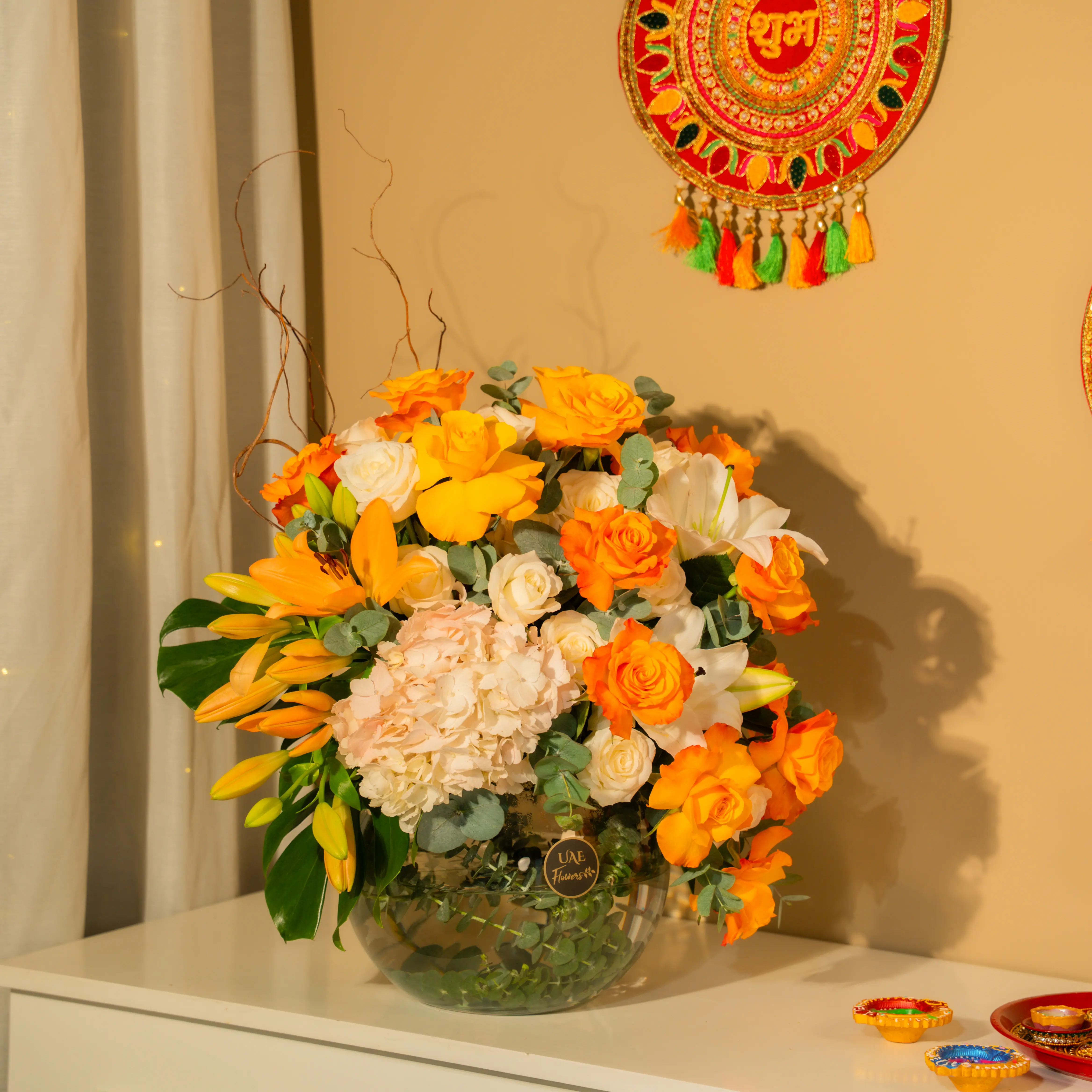 Orange roses, white lilies, and hydrangeas in glass vase for Diwali by UAE Flowers Dubai