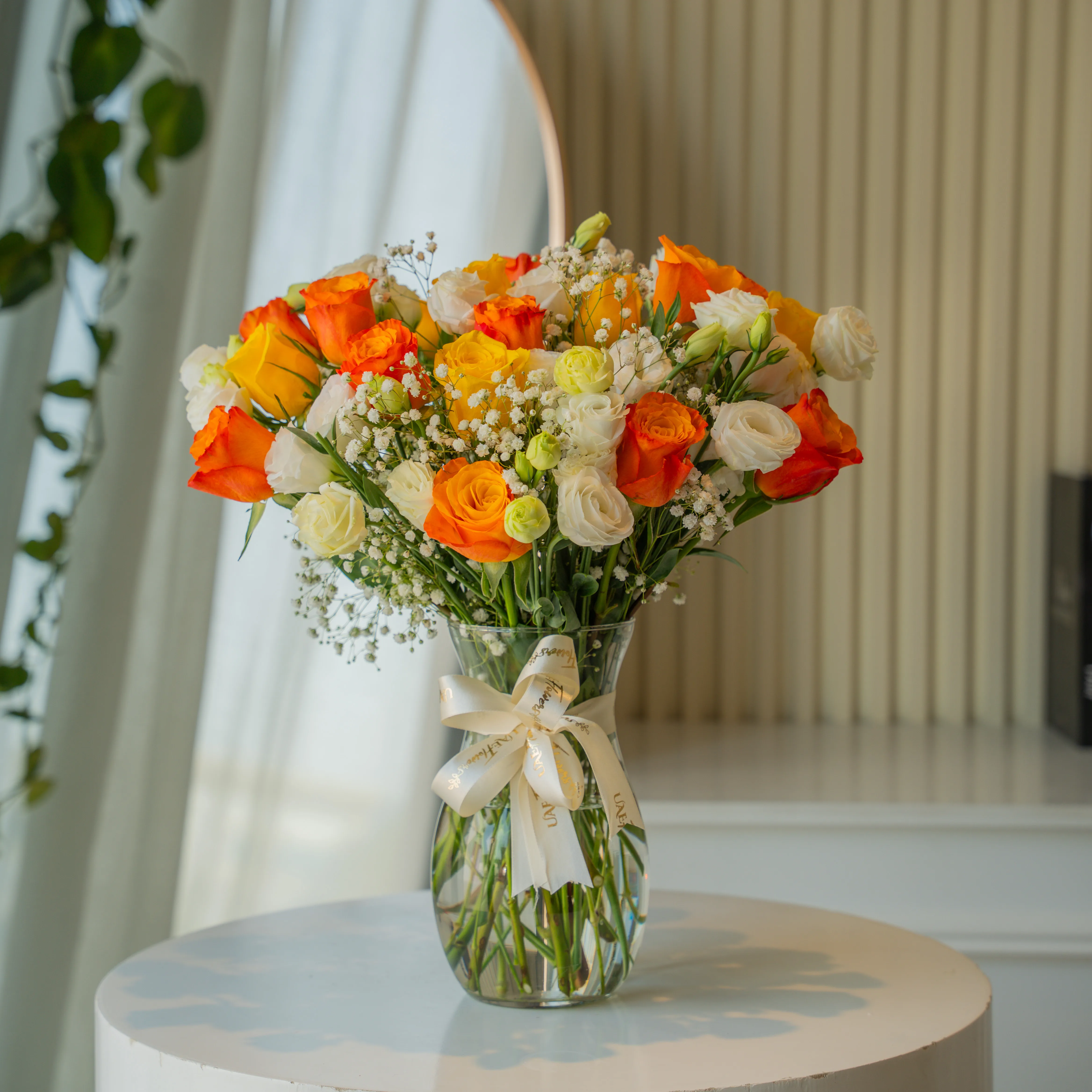 Orange, yellow, and white roses in glass vase for Diwali by UAE Flowers Dubai