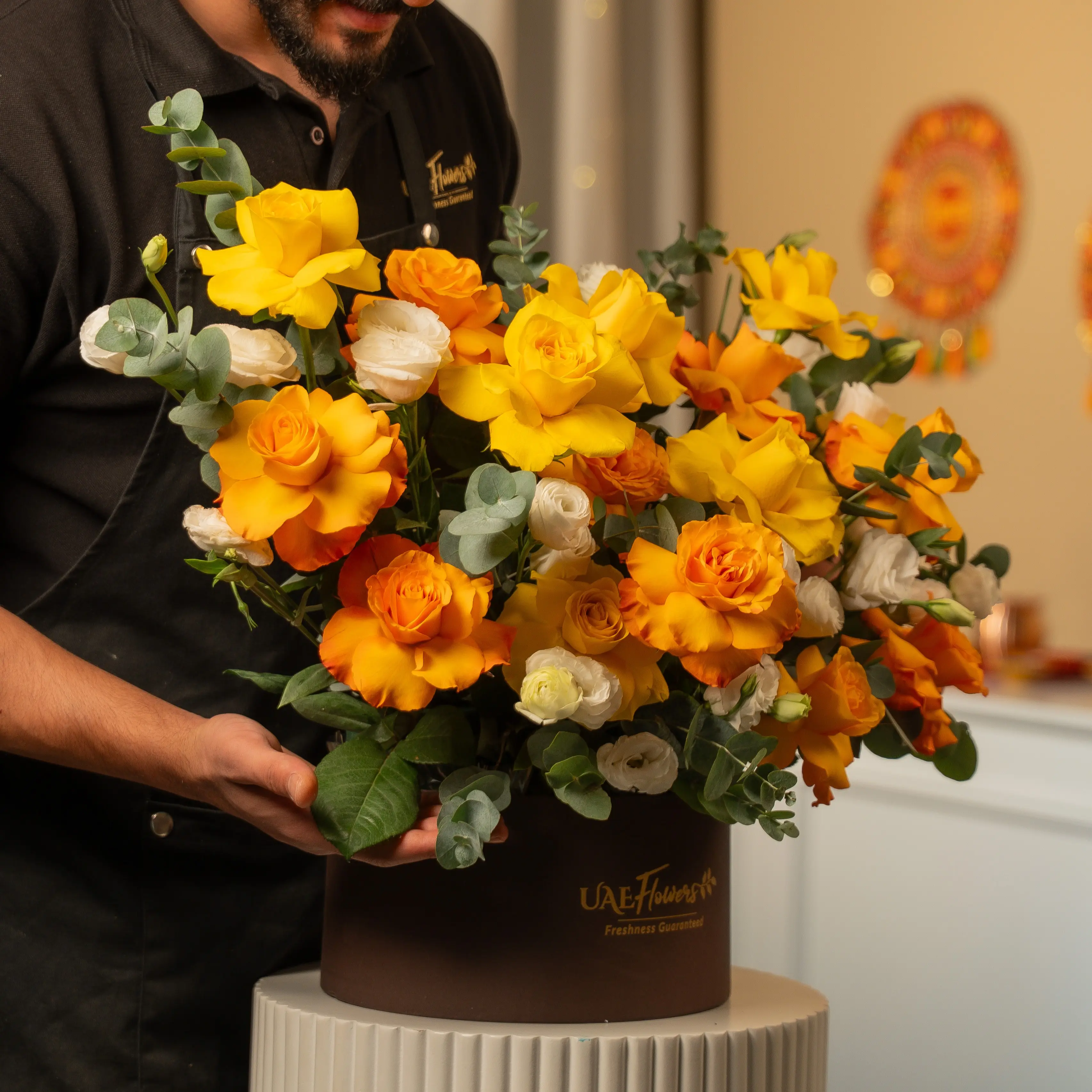 Yellow, orange, and white roses in luxury hatbox for Diwali by UAE Flowers Dubai