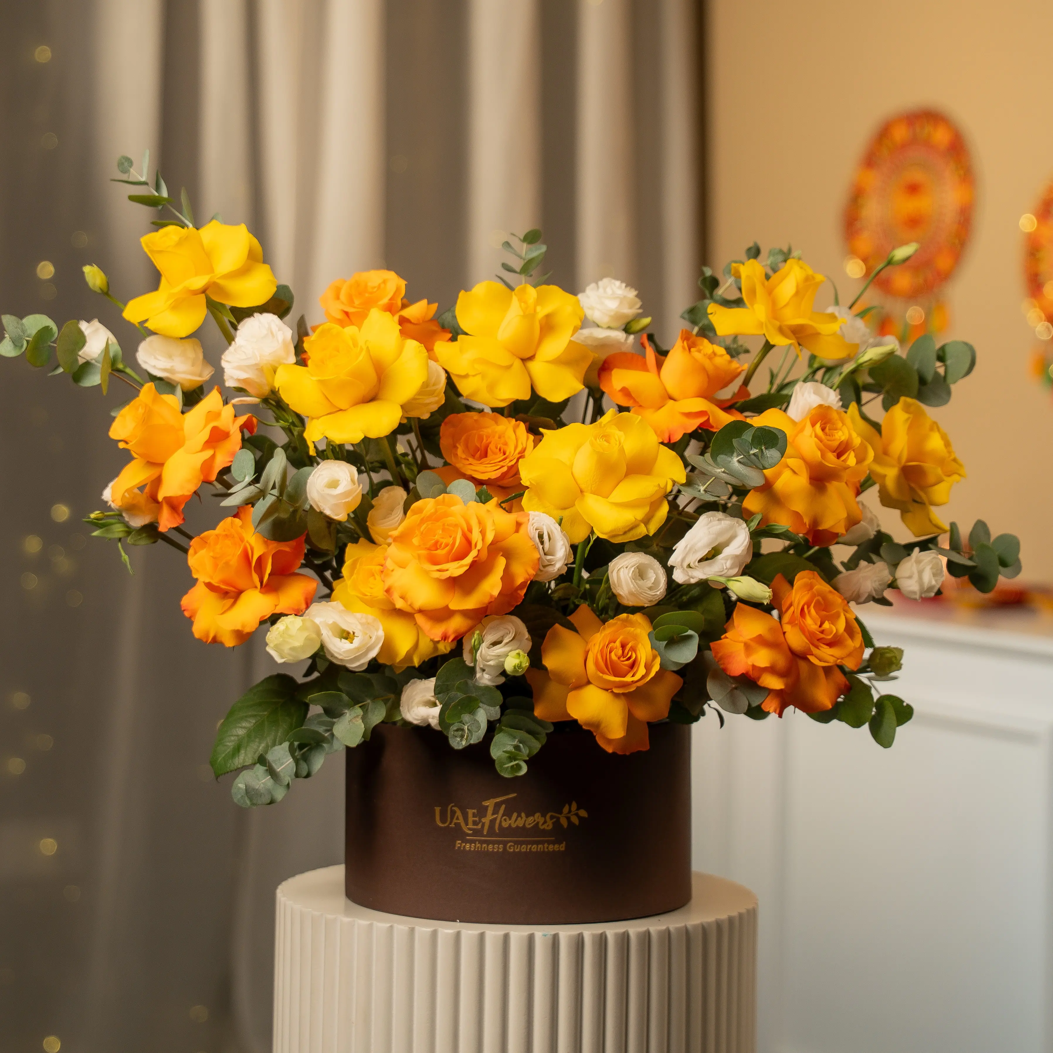 Yellow, orange, and white roses in luxury hatbox for Diwali by UAE Flowers Dubai
