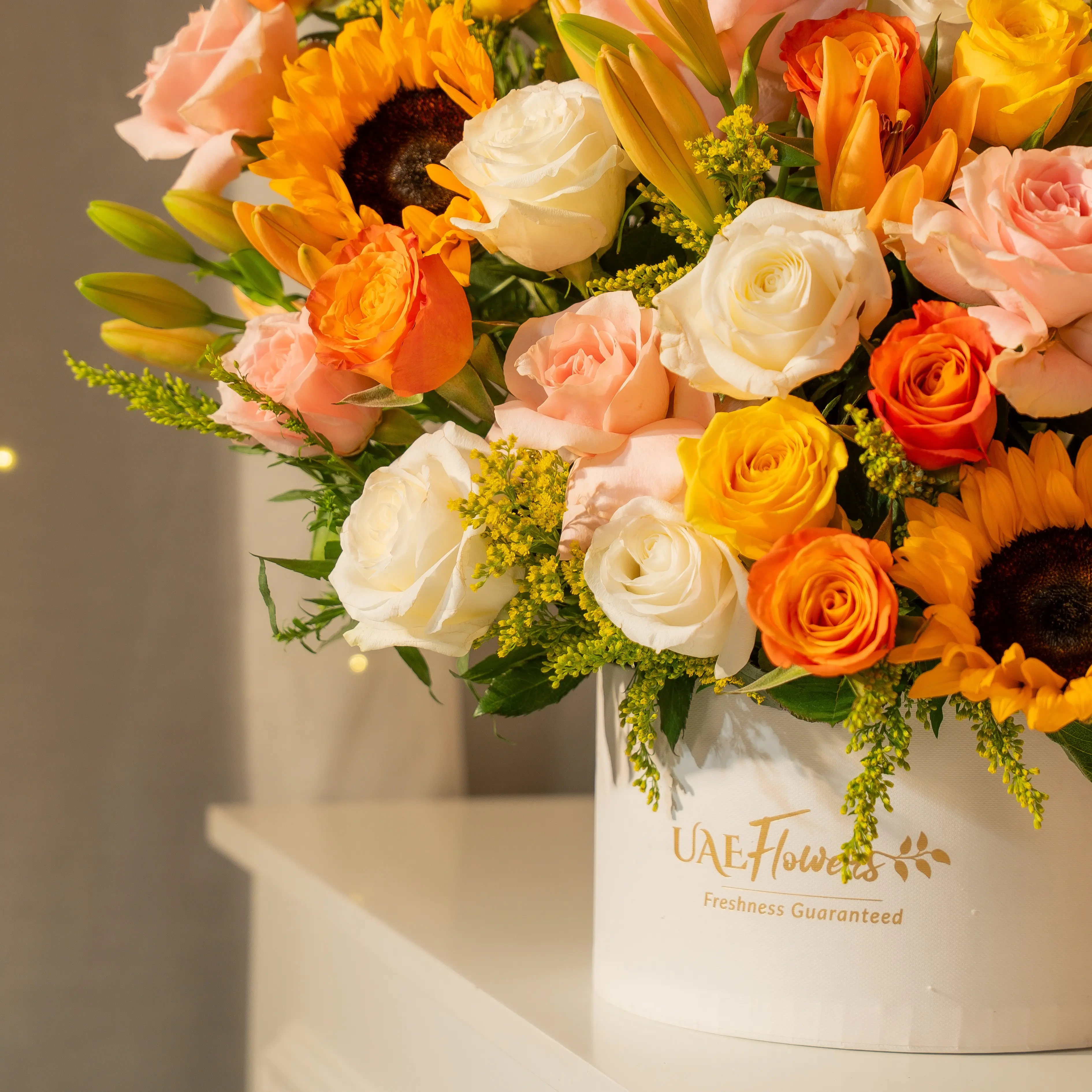Sunflowers, lilies, and roses in a luxury white hatbox for Diwali by UAE Flowers Dubai