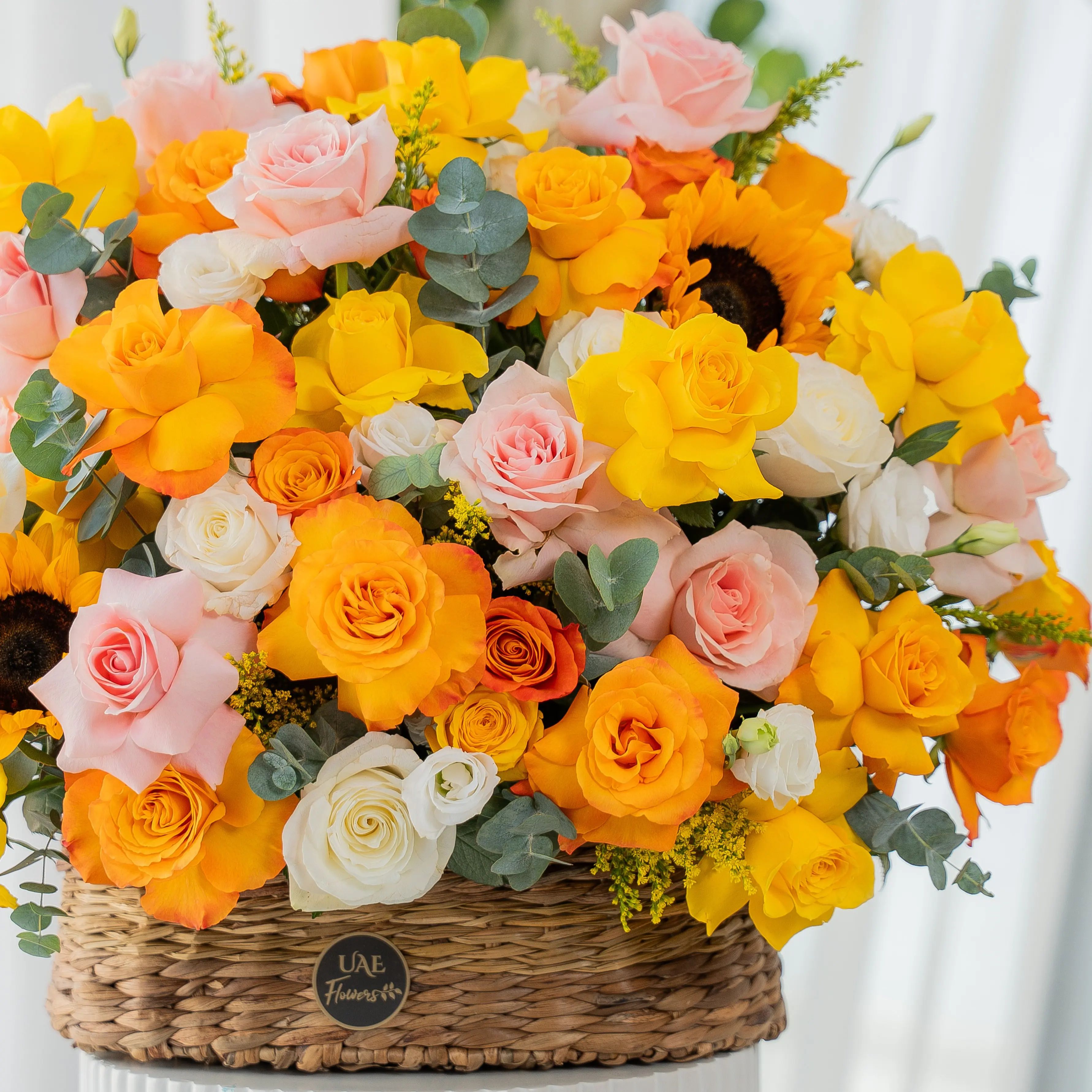 Yellow, peach, and orange roses with sunflowers in basket for Diwali by UAE Flowers Dubai