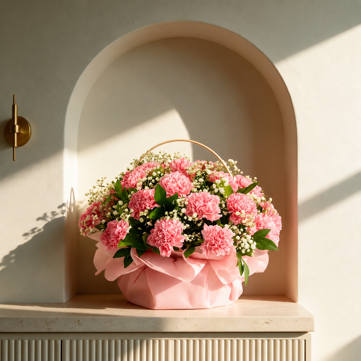 Pink carnation flower basket with baby's breath, greenery and pink ribbon