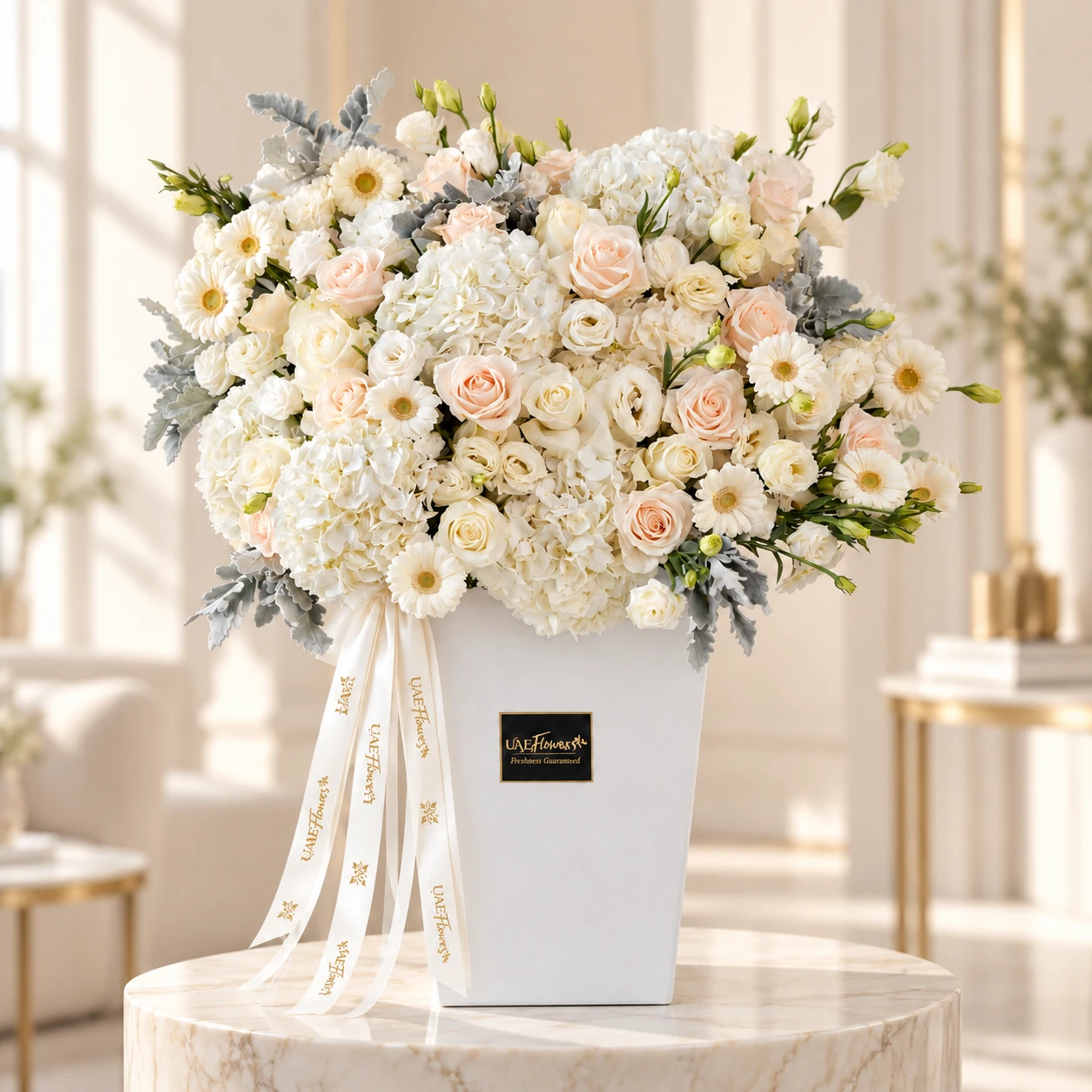 Luxury white flower box arrangement with white hydrangeas, white gerberas, white lisianthus, white and cream roses, and dusty miller foliage by UAE Flowers Dubai.