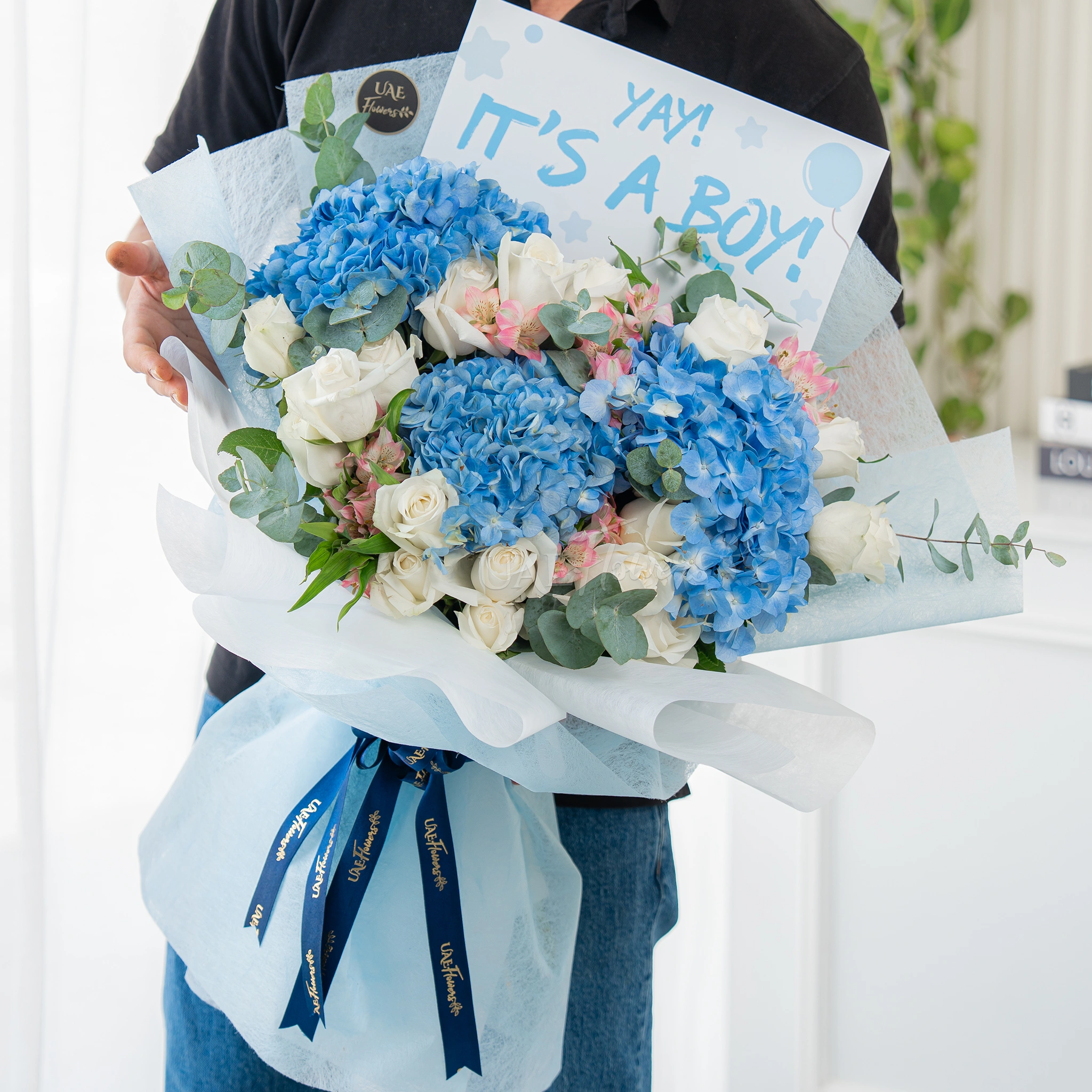 Bouquet of 3 blue hydrangeas, 15 white roses and 3 pink alstromeria with greens in nice wrapping.
