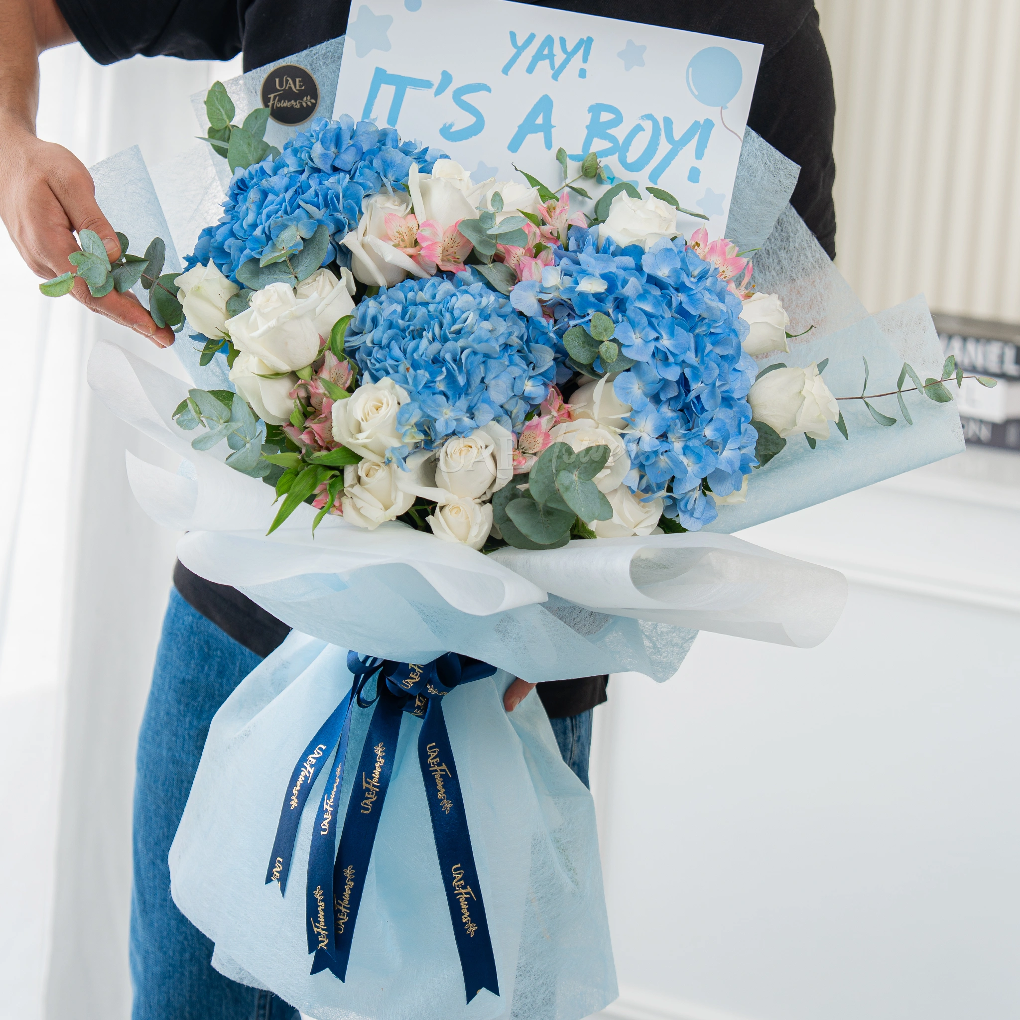 Bouquet of 3 blue hydrangeas, 15 white roses and 3 pink alstromeria with greens in nice wrapping.
