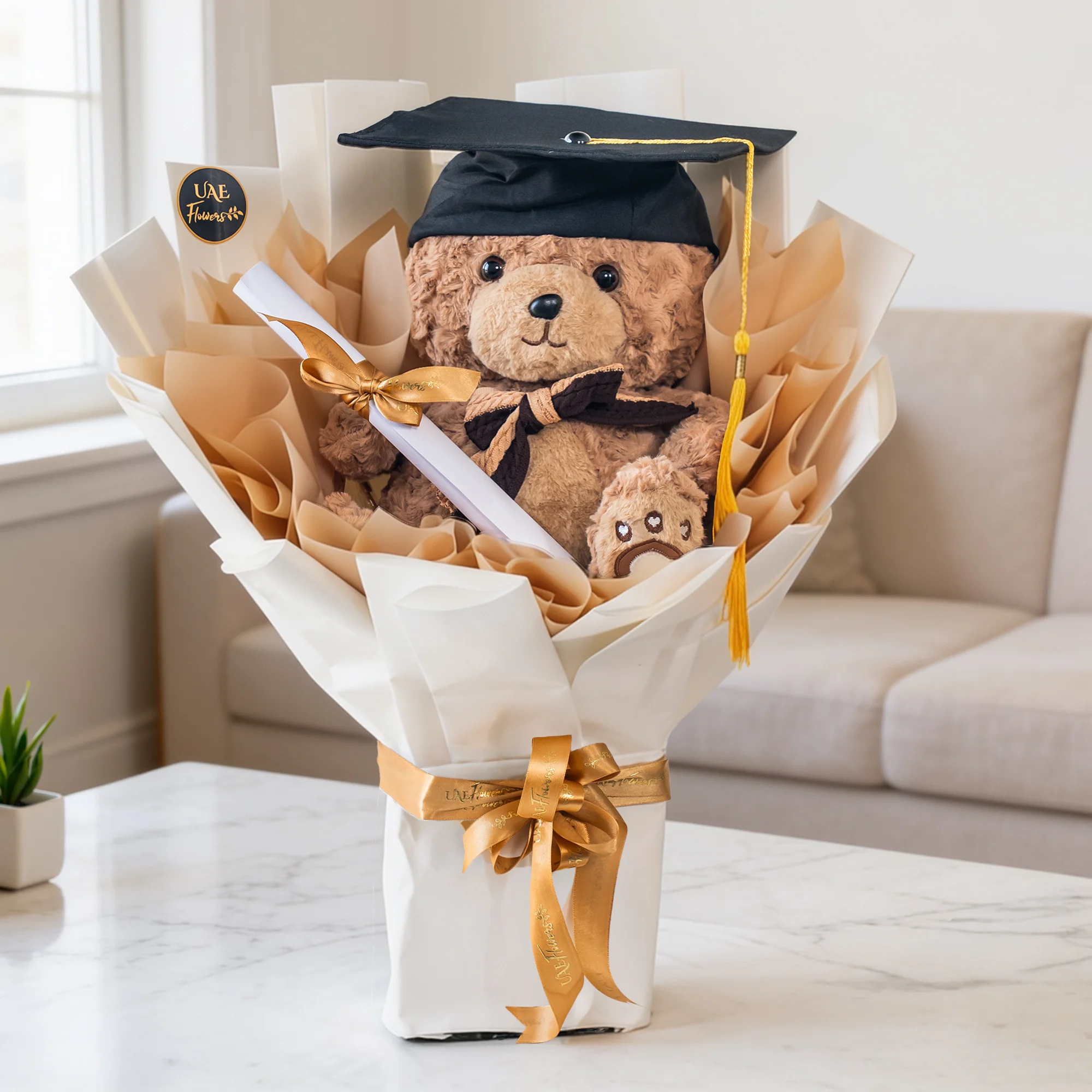 Celebrate academic milestones with our Graduation Teddy Bouquet. Features a plush bear with a cap, stole, and scroll in elegant white and beige wrapping.